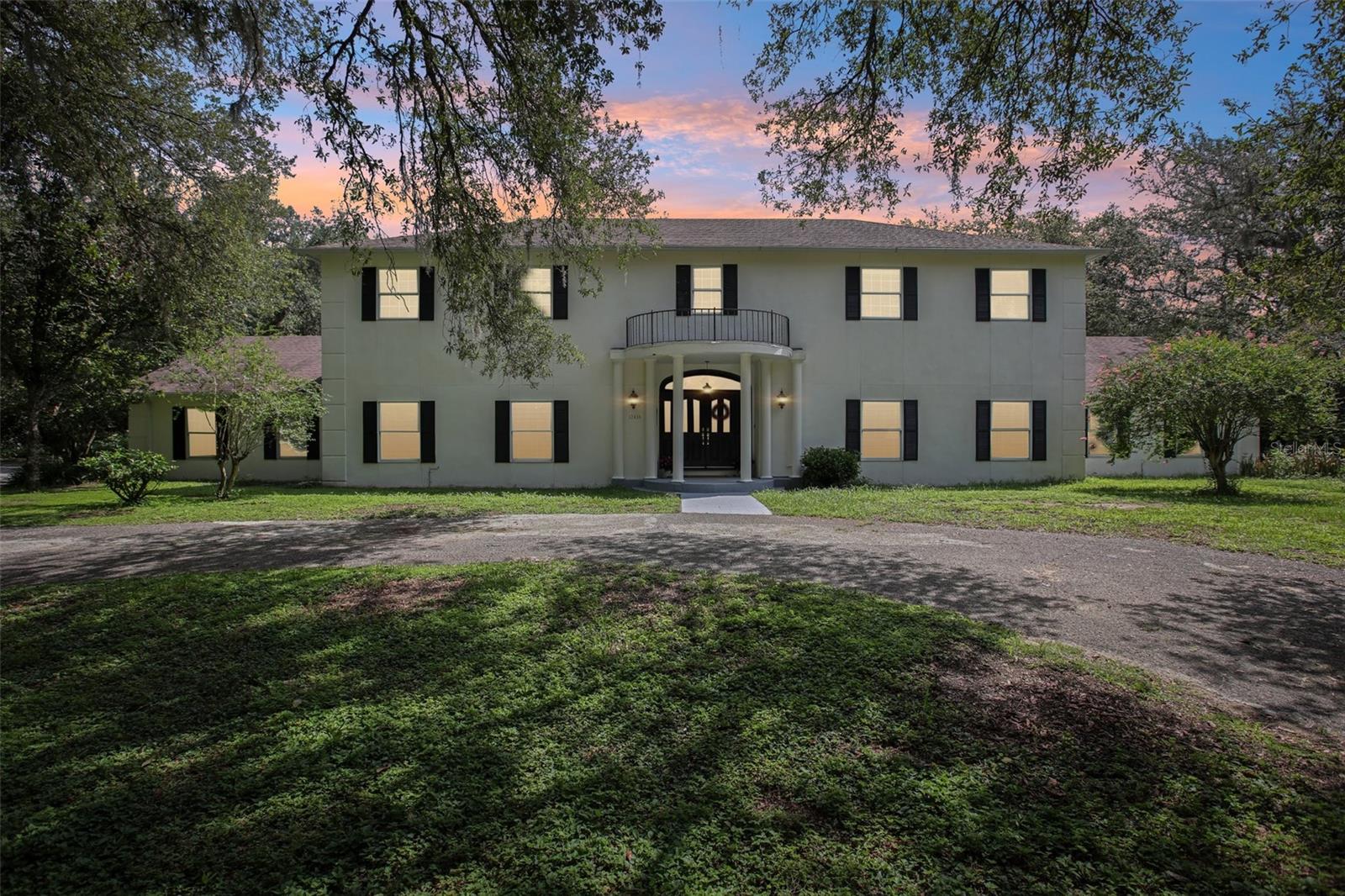Just reduced ~ Experience the charm of Tara Oaks! Tucked beneath a canopy of beautiful live oaks, this lovely estate known as Tara Oaks invites you to experience the timeless beauty of Old Florida living. As you stroll beneath the moss-draped branches of the live oaks the 3.5 acres of lush grounds and dappled sunlight set the stage for a life of grace and comfort. This five-bedroom, five-full bathroom pool home - featuring an in-law suite plus dedicated office, offers a warm, family-welcoming layout designed for both everyday living and elegant entertaining. A grand, sunlit staircase greets you upon entry, leading into traditional formal living and dining rooms that exude classic charm. The heart of the home is a warm and welcoming family room with a cozy fireplace, perfectly positioned to overlook the gorgeous pool and lanai that spans the full expanse of the home. The kitchen is a dream for any home chef or busy family, featuring abundant cabinet space, a walk-in pantry and generous countertops ideal for gatherings and meal prep. Whether hosting holiday dinners or casual brunches, this kitchen is ready to serve and flows seamlessly into the formal dining as well as kitchen dining and family room. A private in-law suite on the main floor includes living room, kitchenette, en suite bath, and separate entrance through the pool-ideal for multigenerational living or long-term guests. Upstairs, the luxurious primary suite offers a peaceful retreat with a private sitting area that can easily be an office or fitness space. Through french doors relax on the balcony overlooking the pool, garden and stunning view of the property. Three additional bedrooms - two with en suite bathrooms and another with direct bath access, provide generous space for family or guests. Downstairs from step outside to the screened lanai that mirrors the scale of the home, where mornings begin with coffee and birdsongs, and evenings end with golden sunsets through the oaks. The sparkling resort-style pool, grand in scale and elegance, complete with a serene spa is the perfect sanctuary for sun-drenched afternoons and tranquil evenings. A former tennis court awaits your vision, restore it for tennis, reimagine it for pickleball, or transform it into a garden or equestrian space. Zoned for agriculture, this estate welcomes horses, chickens, goats, or cows, offering the freedom to live a rural lifestyle with modern comforts. The oversized two-car garage includes a workshop or storage area, perfect for hobbies or homesteading. Don’t miss this rare opportunity to own a piece of classic Florida heritage, where timeless beauty, natural splendor, and modern convenience come together in perfect harmony. *Seller to replace roof prior to closing*