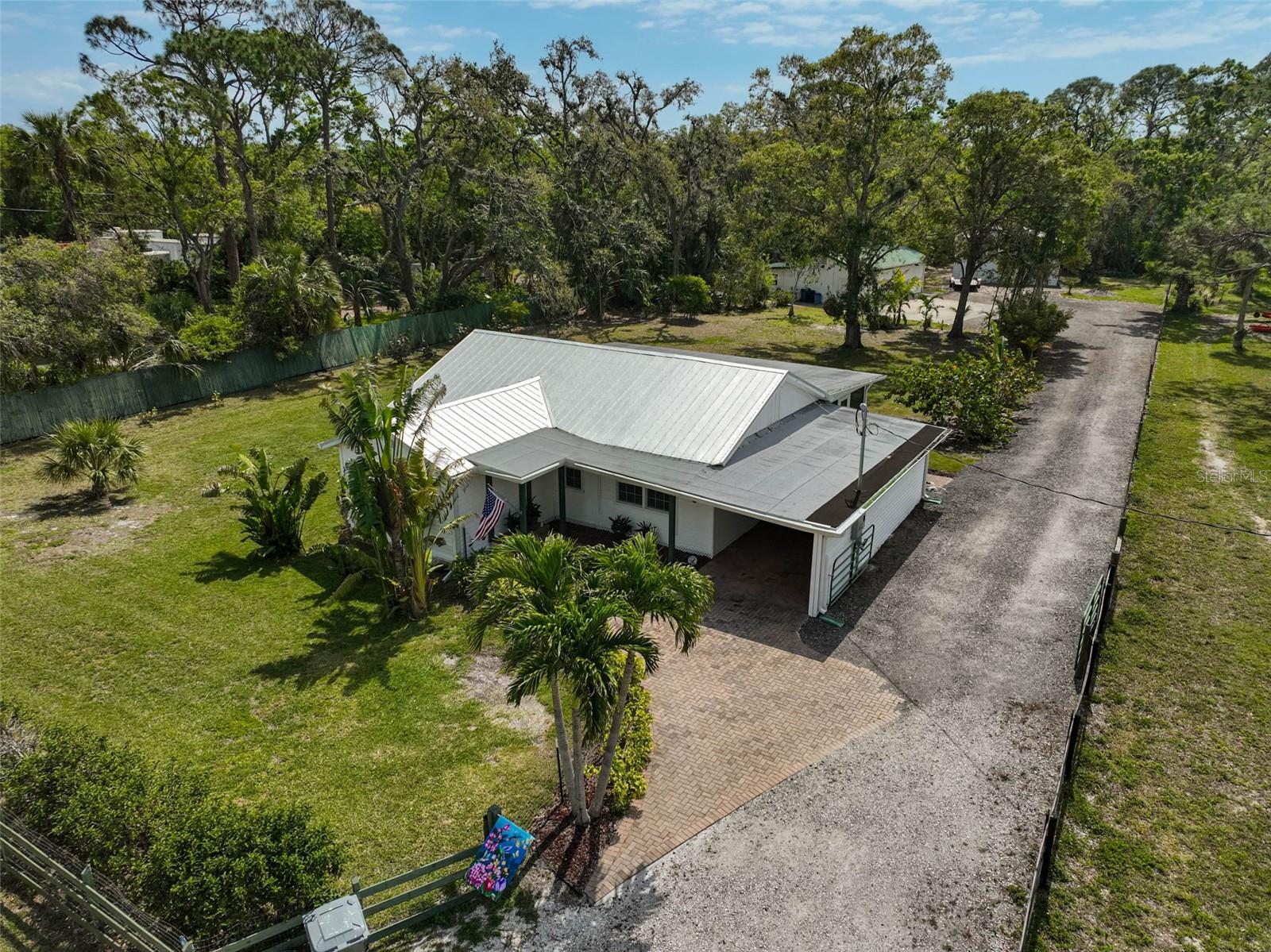 Make all your homesteading dreams come true! This is your sprawling 1-acre retreat right in the middle of town. This delightful single-family home, nestled within the established Elwood Park neighborhood, presents a rare opportunity to own a slice of Florida paradise. Step inside this inviting 3-bedroom, 1-bathroom residence and envision your new lifestyle as you gaze across the property from the expansive screened back porch that spans the length of the home. Included in the 1,283 square feet of living space is a large family room area with vaulted ceilings, beautifully updated bathroom and NEW kitchen appliances! The true magic lies beyond the main residence. Imagine endless weekends spent in the purpose built workshop boasting a convenient half bathroom, mini split air conditioner, and a fantastic recreational bar area – perfect for entertaining friends and family. And that's not all! A massive 30x30 metal building, outfitted with electricity and task lighting, stands ready to house all your biggest tools, toys, or even a home-based business. This property offers the ideal combination of peaceful living and convenient access to all that Bradenton has to offer. Enjoy the warm Florida sunshine, explore nearby beaches, and take advantage of the area's numerous recreational opportunities. Don't miss this exceptional chance to create your dream homestead lifestyle. Schedule your private showing today and experience the unique allure of 4116 34th Avenue East!