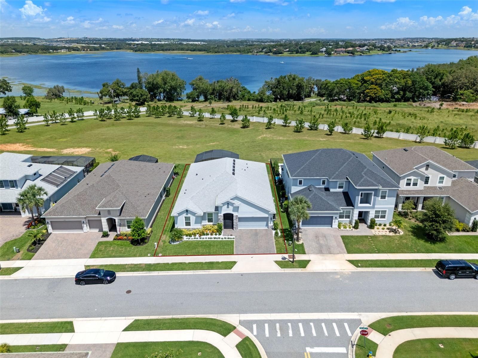 Welcome to your private lakeview retreat in the exclusive gated community of Lakeview Preserve. This stunning 4-bedroom, 3.5-bathroom and 3-car garage home sits on a cul-de-sac and offers breathtaking sunset views over John’s Lake. From the moment you step inside, you’ll notice the attention to detail and high-end upgrades that make this home truly special. The open floor plan flows effortlessly, starting with a welcoming foyer with trey ceilings and crown molding leading to a spacious living area with panoramic lake views. At the heart of the home is the gourmet kitchen, complete with a quartz center island, built-in oven, tile backsplash and 42” cabinets. The kitchen also features a 36" built-in cooktop, designer vent hood, microwave/wall oven combo, and dishwasher... all beautifully integrated for both form and function. Additional highlights include a three-car "showstopper" tandem garage with epoxy flooring, custom storage features, custom lighting, garage pull-down screen and even a custom built-in vacuum and pressure washer system. This home is loaded with over $200,000 in thoughtful upgrades, making it an exceptional value. Pocket sliding glass doors in the living room fully open to the outdoor oasis. Enjoy outdoor living year-round on the 1,000 sq. ft. lanai with full screen enclosure or entertain with ease with your summer kitchen featuring a Paradise Grill, side burner, and outdoor fridge. Additional upgrades include a whole-house water softener system, whole home surge protector, gutters, stone accents on the exterior, a professionally installed closet system in the primary suite, laundry room cabinetry, outdoor holiday trim lighting, premium appliances including the washer, dryer, and refrigerator. The lanai is also pre-plumbed for a future sink. Luxury vinyl plank flooring runs throughout the main living areas, adding warmth and durability. The 596 sq. ft. garage provides ample storage, and the overall design of the home emphasizes comfort, elegance, and functionality. One of the guest bedrooms has an ensuite bathroom making it an ideal in-law or guest suite. Lakeview Preserve residents enjoy access to resort-style amenities including a pool, splash pad, fitness center, playground, fishing pier, and kayak launch. Located minutes from downtown Winter Garden, Clermont, and Mount Dora—with easy access to 429 and the Turnpike—this home offers both convenience and serenity. It’s a rare opportunity to own a fully upgraded, lakefront home in a highly desirable location, with thousands in extras already included. Schedule your private tour today!