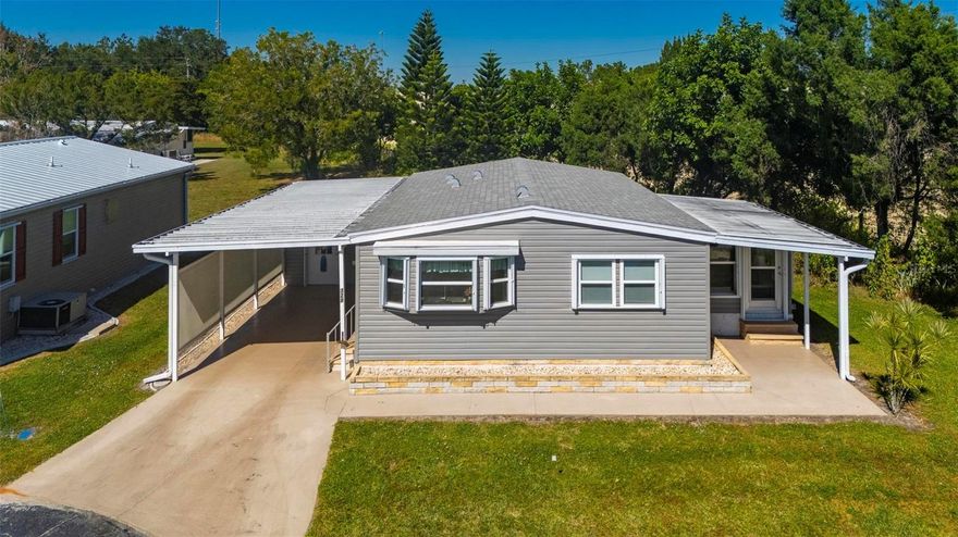 Port Charlotte Village was Voted #1 Manufactured home community in 2024.  Not in Flood Zone. Turnkey 2-bedroom, 2-bath manufactured home nestled in a peaceful 55+ community! This charming home is located at the end of a quiet cul-de-sac surrounded by mature trees, offering privacy and a serene setting. Inside, you’ll find a spacious and well-designed layout with generously sized rooms and plenty of closet space throughout. The large living room is bright and inviting, ideal for relaxing or entertaining guests. The home features all new Samsung appliances, new double-pane windows that help keep the home quiet and energy efficient, a roof from 2022, water heater from 2023, and an updated electrical panel. The kitchen is warm and welcoming with a large bay window that fills the space with natural light, ample counter space, and a pantry accented by a beautiful wood-gliding barn door. The enclosed Florida room offers additional living space with A/C and privacy from the surrounding fence and lush trees — perfect for year-round enjoyment. Outside, you’ll find a large storage shed with a washer and dryer, plus a new carport with privacy screening on one side. This move-in-ready home combines comfort, convenience, and style — the perfect place to enjoy the Florida lifestyle in a friendly and active community!