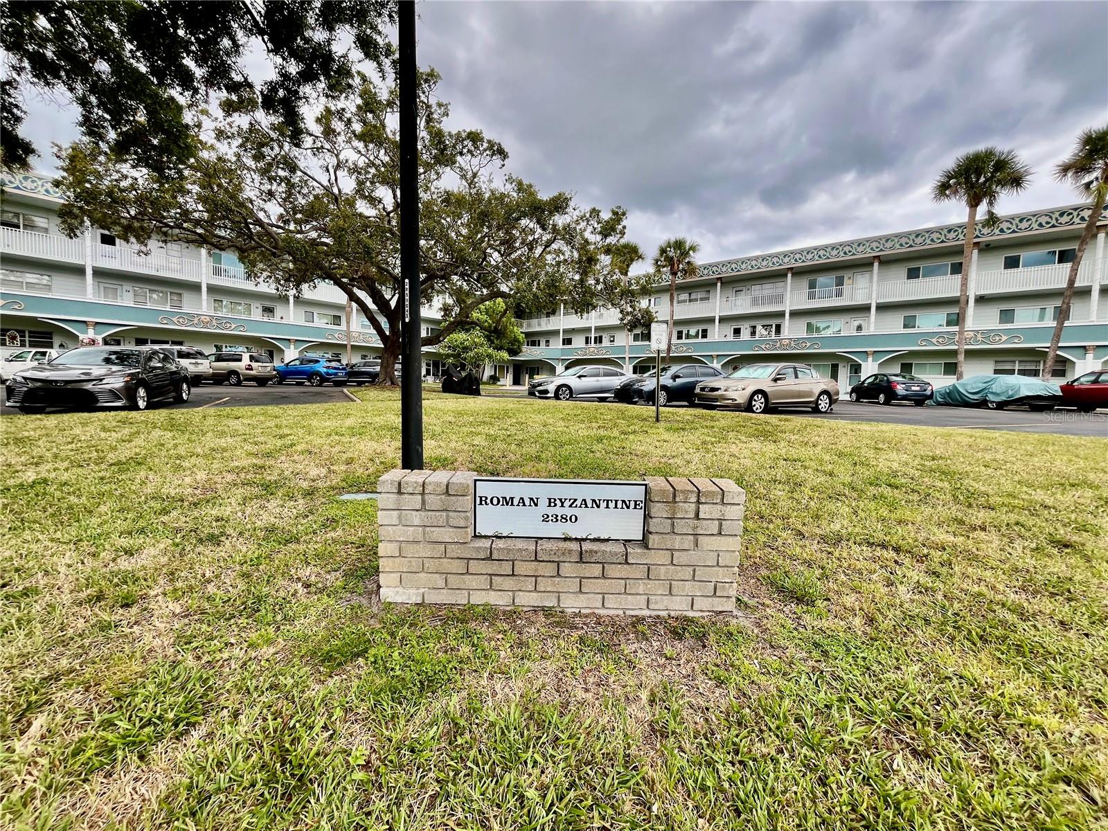 Come see this rare Ground floor End unit which features 1400 sq ft 2-bedroom, 2-bath which is conveniently located near the East Community Center and within walking distance to the golf course! Florida living at its finest! Enter to the spacious and open living room/dining room combo with laminate flooring and fully furnished. The kitchen is light and bright with an eat-in area and features stainless steel appliances. The Florida room has a wall of windows to let in the natural light and a door to the covered patio and green space beyond. The master bedroom has an x-large closet and ensuite bathroom. The second bedroom has a large closet and al. guest bath right down the hall. Assigned parking. The 55+ community has two activity centers, and two private golf courses with 9 and 18 holes, free exclusively for resident owners. There are two heated swimming pools. The remodeled Cardio Gym has the latest exercise equipment. A very pet-friendly community, there is a fenced dog park with covered seating. There are hobby studios, and a wood shop for the exclusive use of the residents. Activities include fitness classes, dancing, clubs, cards, billiards, entertainment, classes, and much more. The on-site Good Karma Café has take & bake meals and snacks. Close to beaches, transportation, shopping, entertainment, and fine dining. All room sizes, floor plans and square footage are approximate. Washer and dryer hookups will be removed before closing.