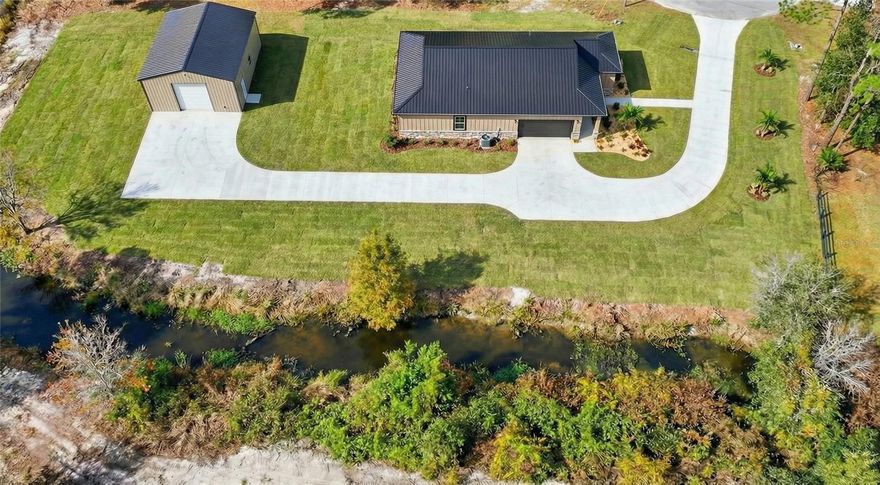 One or more photo(s) has been virtually staged. Under Construction. Under Construction – Completion Estimated July 1, 2026.
Welcome to 8308 Gibson Oaks Dr, where modern craftsmanship meets wide-open North Lakeland living on 2.23 acres with no HOA. This thoughtfully designed new construction by Mitchell Custom Homes, LLC offers a rare blend of luxury, functionality, and space—perfect for those seeking privacy without sacrificing convenience.

The home will feature 2,550 total square feet, including 1,850 square feet of living area, with a 4-bedroom, 2-bath, 2-car garage layout designed for both comfort and entertaining. Interior highlights include 10-foot ceilings, 8-foot doors, electric fireplaces, spray foam insulation in walls and ceilings, insulated windows, and high-efficiency appliances for year-round energy savings.

A standout feature of this property is the 1,200 sq ft detached 30’ x 40’ shop, complete with power and lighting, ideal for a workshop, storage for toys, or business use. The shop and home are positioned on the front, buildable portion of the property, located outside the flood zone, while the rear of the parcel offers a natural drainage canal and conservation buffer—adding privacy and separation from neighboring land.

Surrounded by larger acreage tracts and open pasture, the setting delivers peaceful country living, beautiful sunset views, and the freedom of rural zoning, all while remaining within easy reach of Lakeland amenities, shopping, and major roadways.

This listing represents an under-construction opportunity—photos shown are of a completed model of the same floor plan, showcasing the quality, finishes, and attention to detail buyers can expect. Secure this property now and enjoy the benefits of new construction on acreage with a custom builder.

Photos may include completed model homes and/or architectural renderings of the proposed design. Actual construction, finishes, materials, dimensions, and features may vary. Buyer to verify all specifications, measurements, and details. Listing reflects an under-construction property with estimated completion.

Being listed concurrently with the vacant Land MLS# L4958241