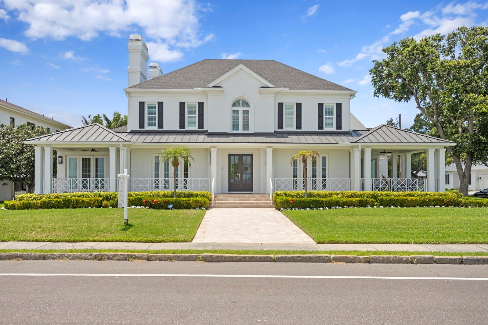 Absolutely stunning home on scenic Bayshore Boulevard situated on an oversized 105x120 corner lot. This stately home was masterfully re-designed by Thomas Everett Lamb - every inch planned to perfection! The spacious front verandas expand the entire length of the home with a modern wrap-around porch that includes a "gazebo" sitting area capturing all the outstanding water and postcard Downtown Tampa views. There is no shortage of exquisite details notable in the extensive millwork, the coffered ceilings, built in bookshelves, wood stained ceiling beams, stacked stone fireplace, unique lighting fixtures, custom drapery, and on and on! You will have a difficult time picking your favorite room as each has its own personality and charm. The serene and peaceful first floor master suite has water views and includes a master bath that is an absolute showstopper with polished marble flooring, alcove with garden tub and surprise ceiling feature. The expansive front living room has a stone fireplace and built-in bookshelves and opposite is the dining room that has a custom wine rack and multiple sets of french doors. The light and bright sunroom sits just off of the kitchen, overlooks the side yard and steps directly to the porch. The family room opens to the large gourmet kitchen with oversized marble topped double islands, custom cabinetry, and top of the line appliances to include Wolf gas range cooktop with sleek exhaust vent, Wolf double ovens, Subzero refrigerator and walk in pantry. Up the main staircase are 3 additional bedrooms, a sitting area, large laundry room, and you do not want to miss the rooftop balcony that has a direct view of the downtown Tampa skyline which is fabulous at night! There is an additional back staircase leading to the 5th bedroom with ensuite bath which is extra private for guests, a nanny quarters, or a bonus/entertainment room. The stunning pool area has lush landscaping, travertine tile decking, separate exterior pool bath, and was designed with multiple venues to entertain while dining, sunbathing, grilling, and relaxing by the home's outdoor fireplace! Flooded with natural light, warm and inviting, this home is a stunning combination of organic textures and modern touches that are one-of-a-kind!