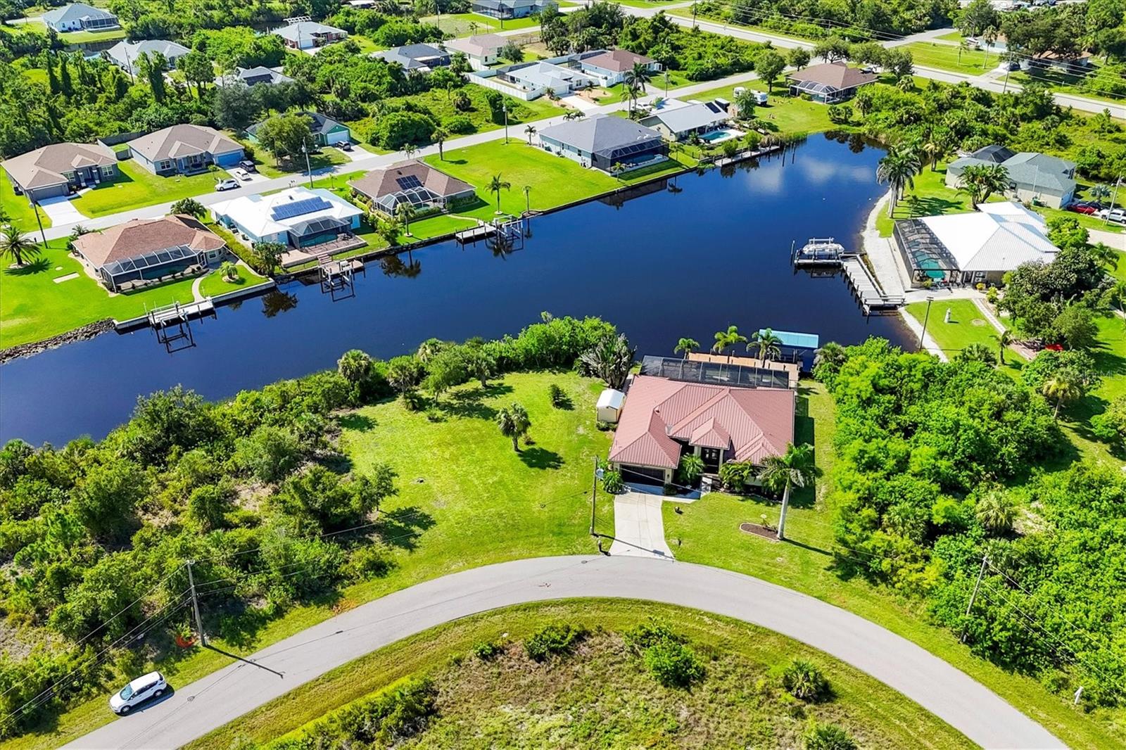 A Grand Gulf Access Sanctuary Built for Beauty, Strength & Serenity!
Prepare to fall in love with this remarkable waterfront estate—an elegant and enduring home where timeless design meets modern construction, and every detail is curated for comfort, peace of mind, and unforgettable Florida living.
Nestled on an oversized waterfront(next door lot available for purchase) lot framed by mature landscaping and majestic trees, this ICF-constructed home (Insulated Concrete Form) offers not only exceptional strength and durability, but also remarkable energy efficiency. With a resilient metal roof, impact-rated glass windows, and roll-down shutters, this home is built to weather the elements while offering the tranquility of a true sanctuary.
Inside, 2,825 sq ft of beautifully finished living space awaits, with 4 spacious bedrooms, 2.5 baths, and a layout designed for effortless entertaining. Soaring ceilings and stately interior pillars evoke a sense of grandeur, while multiple sets of sliding glass doors invite natural light and showcase breathtaking water views from nearly every room.
The heart of the home is the stunning chef’s kitchen, featuring rich staggered cabinetry, gleaming granite countertops, newer stainless appliances, and a large walk-in pantry. This space opens seamlessly to the main living areas, creating a perfect flow for gatherings both large and intimate.
The expansive primary suite is a private retreat with serene waterfront views, dual vanities, a luxurious garden tub, and a Roman-style walk-in shower. Guest bedrooms are generously sized, offering comfort and space for visitors or family.
Just off the main living space, a sprawling entertainer’s retreat offers endless possibilities—perfect for a full bar setup, billiards, home theater, or game nights with family and friends.Step outside into a tropical haven designed for true Florida living. The saltwater pool is solar heated and surrounded by a spacious lanai and sun deck—ideal for entertaining, relaxing, or simply taking in the breeze off the water. A large tiki hut offers a shaded escape, perfect for outdoor dining or afternoon lounging. The 8x12 outdoor storage shed provides additional space for tools, toys, or hobbies.
Boating enthusiasts will be thrilled by the private dock with a covered lift, offering easy access to open water adventures. Whether sipping coffee at sunrise or hosting a vibrant evening dinner party, the panoramic water views provide a constantly changing backdrop of natural beauty.
This is more than just a home—it’s a legacy property, thoughtfully designed and lovingly maintained. A rare combination of elegance, efficiency, and durability, all set in one of the most desirable waterfront locations Florida has to offer.