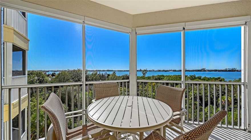 Built in 2019 and perfectly positioned on the fourth floor, this waterfront residence offers sweeping views across the Intracoastal Waterway, tranquil mangroves, and surrounding waterways from nearly every room. Designed with comfort and functionality in mind, the three-bedroom plus office layout spans nearly 2,200 square feet of interior living space and captures the essence of relaxed coastal living.
Inside, the open floor plan is finished with travertine and Brazilian cherry wood flooring, crown molding, and wood-encased impact windows that frame the water views. The granite chef’s kitchen features solid-wood cabinetry, an Italian Carrara marble backsplash, center island with pendant lighting and seating, and upgraded stainless-steel appliances including a beverage refrigerator. The kitchen flows seamlessly into the formal dining area—anchored by a custom metal-and-granite dining table (included)—and the living room, where walls of glass sliders open to an oversized, screen-protected terrace.
The terrace extends the living space outdoors with tile flooring, ceiling fan, and custom electronic shades—ideal for morning coffee, sunset gatherings, or quiet evenings overlooking the water. Additional interior highlights include custom shelving in all bedroom closets, automatic sunscreen in the living room, LED lighting throughout, and an oversized laundry room with premium appliances, generous granite counters, and abundant storage.
The secluded, west-facing primary suite offers peaceful water views, French-door access to the balcony, dual walk-in closets, and a granite-finished en-suite bath. Two guest bedrooms (one with a walk-in closet) are positioned on the east side of the residence for privacy and share a granite and glass bathroom, creating a comfortable retreat for visitors.
Residents enjoy the full suite of resort-style amenities at Edgewater at Hidden Bay, including a heated pool and spa, tiki-hut covered grilling and lounge areas, clubhouse with catering kitchen, library, fitness center, tennis and pickleball courts, kayak launch and storage, picturesque boardwalks through mangroves and lakes with fountains, and a private fishing pier currently undergoing improvements.
Ideally located near Siesta Key and Nokomis beaches, this residence is also minutes from Bay Street Park, the Legacy Trail, Oscar Scherer State Park, marinas, golf courses, shopping, dining, and premier medical facilities. Offering a blend of waterfront serenity and everyday convenience, this home delivers an exceptional coastal lifestyle with easy access to everything Sarasota has to offer.