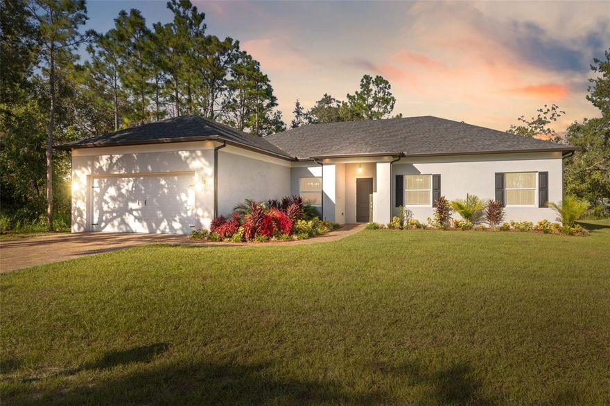 One or more photo(s) has been virtually staged. This stunning 3-bedroom, 3.5-bathroom home with a 2-car garage sits on a beautifully landscaped oversized corner lot, offering both privacy and elegance. The property features a split floor plan and an open layout with luxury vinyl flooring throughout. The primary suite includes two spacious walk-in closets and an elegant en-suite bathroom with a double vanity, a step-in shower with floor-to-ceiling calming gray tile, a private water closet, a separate soaking tub, a built-in wall niche, and a window for natural light. The additional bedrooms each include walk-in closets and private en-suite bathrooms with tub/shower combinations, and all three full bathrooms feature state-of-the-art LED vanity mirrors with touch controls and luxurious floor-to-ceiling tile. The open-concept kitchen and living area offer both comfort and style, highlighted by wooden ceiling beams, solid wood cabinets, stone countertops, and picture frame wainscoting in the living and dining rooms. The gourmet kitchen features two gas ranges framed by a stunning stone wall and upscale white tile backsplash, stainless steel appliances, granite counters, and two sinks—one in the island/breakfast bar and another beneath a window with beautiful outdoor views—along with a large walk-in pantry and contemporary two-tone cabinetry in light and dark grays. The living room opens through sliding glass doors to a spacious rear covered porch overlooking a peaceful yard surrounded by oak trees and natural woodlands, and a versatile office off the living room can also serve as a fourth bedroom. The laundry room includes a closet, storage shelving, sink, and convenient corridor access, while additional highlights include high ceilings, double-pane Energy Star-qualified windows with impact and thermal glass, a fuel tank, and a full irrigation system. Current homeowner’s insurance is approximately $1,200 per year, and no flood insurance is required as the property is not located in a flood zone. This home offers a rare blend of elegance, comfort, and privacy while remaining close to Weeki Wachee Springs, Hernando Beach waterfront dining, and Brooksville Country Club, making it the perfect balance of modern living and Florida natural charm.