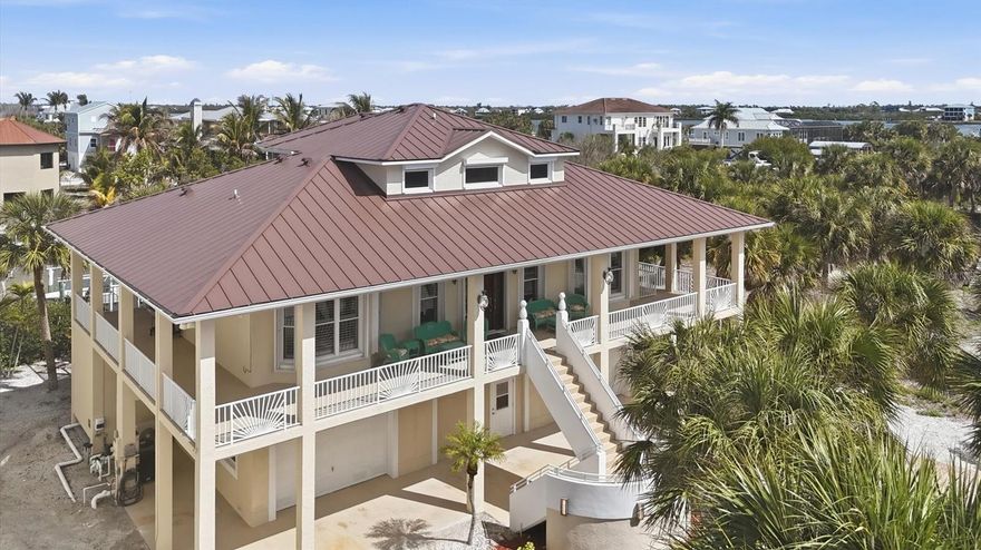 Palm Island – A Beach lover and Fisherman’s dream come true. This concrete 3-story home (one of the few concrete homes on the island) brags of space and easy living. With its location on a deep-water canal that leads directly to the intracoastal waterway, it’s a quick boat ride to some amazing fishing inshore and offshore. On the island, a short golf cart ride takes you to the quiet, shell-lined beaches for a lazy day in the sun or beautiful sunrises or sunsets. Look for some shark teeth while you are on the beach! Downstairs between spacious garages is a game room/hobby room for families of all ages. The beautiful pool sits just outside the game room with plenty of covered space for the non-sun lovers and open space for those that do love the Florida sun! The pool has a sun shelf and a hot tub. On one side, there is room off one of the garages that has the beautiful pool view and can be used as an office or extra bedroom and the area has a full pool bath just off the pool. On the other side of the pool is a storage/fishing room. The dock has two boat lifts – one for your fishing boat and the other for your fun jet ski. As you ascend up the steps to the main living area, a wraparound porch awaits with multiple places for sitting, grilling and entertaining. As you enter the front door, there is an open room for dining and relaxing with a sitting area that has a half bath. The kitchen boasts of lots counter space and easy flow and is open to the dining area for easy entertaining and family meals. The two bedrooms off the living area are on each side of the full bath. Upstairs you’ll find a private, expansive master bedroom and bath with two large closets. Off the master suite, there is another covered porch with a view of the intercoastal. With concrete construction, hurricane shutters and a new metal roof installed in 2023, this home blends durability with coastal sophistication. Come step into a world where life slows down and peaceful living take center stage.