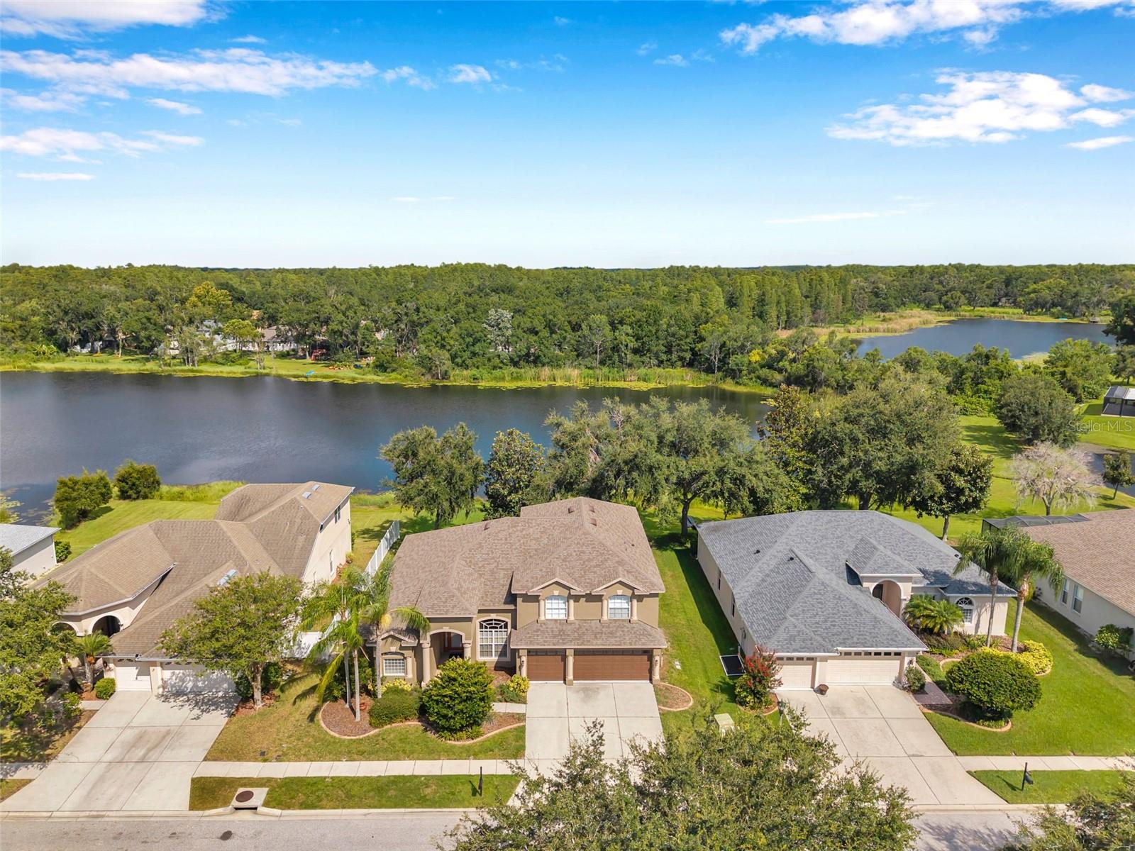 Beautiful 5 bedroom, 3 bath, 3 car garage, LAKE VIEW home in the GATED community of Lake Talia. A well-maintained neighborhood in the perfect location, it's ready for you to call it home. Situated on an almost quarter-acre, 80 foot wide lot, you'll enter to a lovely living room / dining room combination with sliders to the COVERED & SCREENED PATIO and AWESOME VIEW OF THE LAKE. The whole home has been UPDATED with BEAUTIFUL LUXURY VINYL PLANK FLOORING & NEW EXTERIOR PAINT! Follow the OPEN FLOOR PLAN to the kitchen with NEW STAINLESS STEEL APPLIANCES and family room with amazing two-story ceilings and tons of natural light! (More lake view here!) This 4-WAY SPLIT FLOOR PLAN really gives everyone their own space. The already spacious master bedroom is located on the ground floor on left side of the house and adds an extra sitting room with lake view, perfect for relaxing (or home office if preferred). The en suite master bathroom with dual, split vanities, garden tub, NEW FRAMELESS GLASS SHOWER, along with 2 WALK-IN CLOSETS complete this primary retreat. Another bedroom is also located on the ground floor with a full bathroom just off of it, great for a guest room. Three LARGE SECONDARY BEDROOMS with WALK-IN CLOSETS are located upstairs with a cute little loft area that overlooks the family room and kitchen. It even has a built-in desk for studying, reading, or organizing bills. Upstairs bathroom has DUAL VANITY & shower / tub combo. Large, downstairs laundry room has utility sink and a GREAT STORAGE CLOSET under the stairs for your extra stuff. 3 car garage and wide driveway allow for extra vehicles and really complete this fabulous home. Lake Talia has a park & playground / picnic area / full court basketball, not to mention great sidewalks / paths / benches along water views. READY FOR A QUICK MOVE-IN! Call today for your private showing!