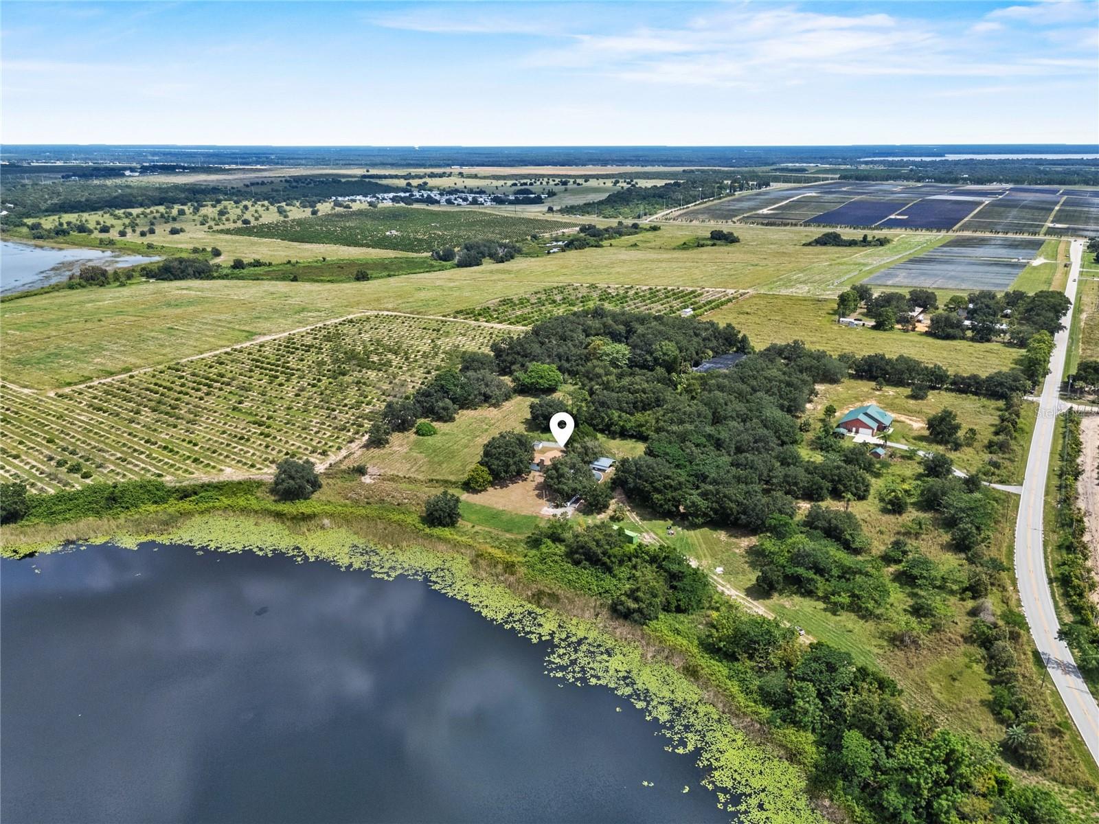 Lakefront home on acreage on the outskirts of Lake Wales, Florida—welcome to 660 Duggers Way, a property offering 1.6+ acres of high and dry land, no HOA and over 300' of lake frontage across two parcels. This unique opportunity includes a 0.88-acre homesite with a spacious 2,200+ square foot residence plus an adjoining 0.77-acre lot, both overlooking the scenic waters of Lake Lee. Whether you’re an outdoor enthusiast, a business owner needing space for equipment, or someone with boats, cars, or RVs, this hidden oasis delivers the perfect blend of privacy, room to spread out, and water frontage. A private drive leads to the residence, a once-bustling lakefront retreat now ready for updates and offering incredible upside potential.
Inside, the home features an expansive floorplan with oversized rooms throughout. The main level opens into a welcoming great room anchored by a wood-burning stone fireplace, soffit accent lighting, and abundant space for both entertaining and relaxation. The kitchen offers plentiful cabinetry, counter space, and easy flow to the dining area, making meals and gatherings convenient. The oversized primary suite includes a walk-in closet and private bath with a walk-in shower and makeup vanity. A split guest suite with its own walk-in closet and full bath ensures comfort and privacy for family or visitors, while a laundry room completes the main floor.
The lower level, with its own private entrance, expands the possibilities with a large bonus room, office, and storage/bedroom option—perfect for multi-generational living, hobbies, or even a home-based business. Vehicle and equipment storage is no issue with a two-car garage plus an additional two-car covered carport, offering ample protection for cars, boats, or recreational vehicles.
Major system updates provide peace of mind and long-term value: new AC in 2018 with motor replaced in 2024, a new roof in 2023, and a new well tank and pump in 2025.
Outdoors, the property captures the essence of quiet, natural Florida living. Lake Lee is known for great fishing, abundant wildlife, peaceful waterside views, and dramatic sunset skies, creating a perfect backdrop for relaxation or outdoor adventure. The land sits high and dry above flood plains, providing additional security.
Located just minutes from Hwy 27, this property offers the best of both worlds—seclusion and convenience. You’ll be close to shopping, dining, schools, and medical facilities, while still within a short drive of Tampa, Orlando, Disney attractions, and Florida’s renowned east and west coast beaches. With privacy, acreage, no HOA, water frontage, recent updates, and limitless potential, this is truly a one-of-a-kind property that’s nearly impossible to replicate.