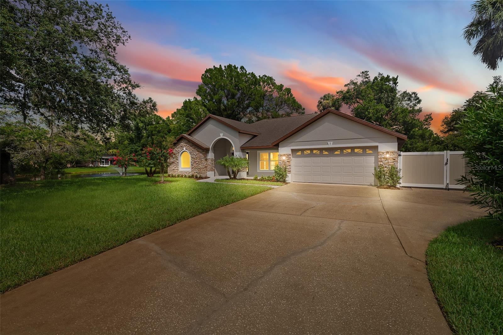 Welcome to your turn key dream home, nestled on a gorgeous third of an acre lot. This stunning 4 bedroom, 2 bath home offers everything you've been looking for and has been completely and meticulously renovated where every detail has been thoughtfully curated, ensuring the utmost in style, comfort and visual harmony. Home sits on a beautiful, professionally landscaped lot that features lush, tropical greenery, mature oak trees, and a tranquil pond and is ideally situated at the end of a quiet cul-de-sac. As you enter the home through the brand new double etched glass doors and charming front porch adorned with stone accents, you'll be in awe of the unique architectural features this home has to offer. The volume ceilings, attractive niches, gorgeous LVP flooring, tasteful color palette, and high end finishes, all exude elegance and the perfect blend of modern and traditional elements that make every aspect of this home appealing and inviting. The newly modeled and intuitive design of the state of the art kitchen is truly the heart of the home, featuring top of the line brand new stainless steel appliances, brand new 42 inch, soft close wood cabinets with dovetail soft close drawers, gorgeous quartz countertops and oversized center island with storage, overhead pendant lighting, real marble backsplash, custom wood range hood, complete with wall oven and microwave make the kitchen a chef's haven. The open and airy family room showcases a custom, true stone, floor to ceiling fireplace wall that is accentuated by a real wood mantel, remote controlled smart electric fireplace insert, and an articulating TV mount that fits up to an 86 inch TV. The owner's suite has an unobstructed view of the pond with water fountain, French glass doors that lead to the covered and screened lanai and boasts an expansive, fully custom ensuite that is an absolute show stopper designed to provide style and sophistication that encompass the ultimate in luxury and features an impressively large step in glass shower with porcelain tile, built in hidden niche, dual shower heads, dual custom vanities with quartz countertops and two large walk in closets. On the opposite side of the house are three additional bedrooms, each generously sized, providing comfortable spaces for family members or guests, and an updated full bathroom with porcelain tile and custom quartz vanity. Other key notable features include: fully fenced back yard, able to store a boat or an RV and have the option of putting another gate on the back side of the fence to allow easy and straight pull through access of a boat or an RV to the road behind the house, roof (2023), HVAC (2020), water heater (2024), new windows with LIFETIME WARRANTY , new lighting throughout, new fans throughout, all new plumbing fixtures, new garage door opener, generator outlet, new paint interior & exterior, new LVP floors, new garage floor paint. Traceways is a quiet, well established neighborhood, that offers the perks of city living yet its conveniently tucked away just enough, making it a true hidden gem community that offers a unique blend of charm and affordability in one of the best locations in Ormond Beach with it's close proximity to beaches, shopping, dining establishments, recreational facilities and easy access to SR-40, I-95, and I-4.