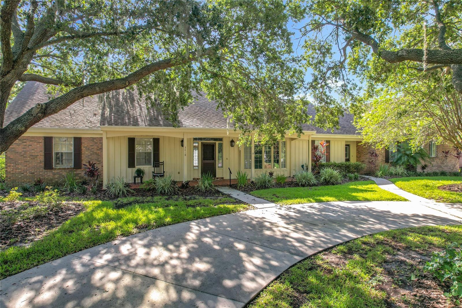 Prime Location in Oakbridge! This home is ideally situated just minutes from medical facilities, shopping centers, and a wide variety of dining options. Home is built on pilings and offers both charm and functionality. a circular drive welcomes you to a spacious 3 bedroom 2 1/2-bathroom design. Inside the home features include: a welcoming foyer that sets the tone for the homes inviting style, dining room is accented with classic wainscoting, adding a timeless charm. The living room and family room have their own cozy fireplaces and a wall of built-ins; the family room also features a built-in wet bar. The master bedroom retreat features a stunning stained-glass window, adding natural light, the window treatments throughout the home adds style and comfort. Kitchen comes with solid surface countertops, ideal for everyday use. Just off the kitchen a cozy eating area provides the perfect spot for casual meals, or a morning coffee. The home also includes a laundry room complete with washer and dryer, adding everyday convenience. Step outside to enjoy the screened porch, sparkling pool, and a brick patio with a retractable awning. A large concrete pad provides ample space for parking or outside entertaining. The extra-large garage provides ample storage, and the mature landscaping with sprinkler system adds privacy and curb appeal. A home with location, space, and comfort complete this one-of-a-kind property, just waiting for a new family to make it their own.