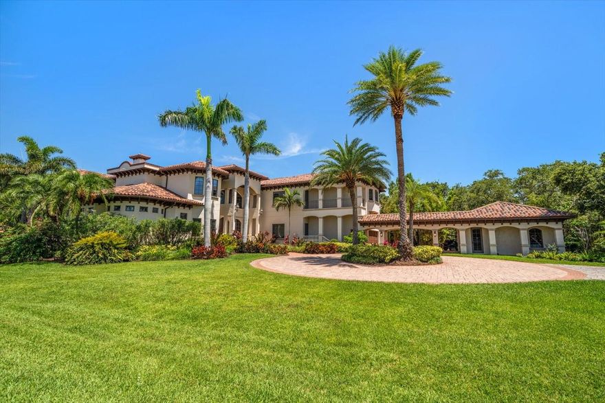 An estate where two elite worlds unite- WATERFRONT luxury & EQUESTRIAN prestige. Tucked away behind a canopy of majestic oaks, a winding Tennessee fieldstone driveway leads you to a Mediterranean-inspired masterpiece that redefines elegance and luxury. Crafted by renowned Brandon Construction, this private estate is a true tropical paradise, created for those with the most discerning taste. Custom double entry doors open to an awe-inspiring interior—where sophistication and thoughtful design meet. The private office offers quiet productivity, while the breathtaking living and dining room commands attention with soaring floor-to-ceiling windows that perfectly frame the resort-style pool and lush outdoor living areas. The chef’s kitchen is the heart of the home, featuring granite countertops, a center island with prep sink, breakfast bar, pot filler, custom built-in Miele fridge & freezer, gas cooktop, and a walk-in pantry—all open to a warm and spacious family room with beamed coffered ceilings, a cozy fireplace, and sliders to the outdoor oasis. Every detail has been considered, from the pool bath, mudroom, and laundry room to the theater room with stage and stadium seating—ideal for movie nights or performances. The primary suite is a serene retreat, flooded with natural light and accented by rich wood beams, a jaw-dropping custom walk-in closet with center island, and a spa-like bath with jetted tub, double walk-in shower with triple heads, dual vanities, a dressing table, and a hidden passage to the home office. Additional bedrooms and bathrooms are designed to pamper family and guests alike. Step outside and you’re transported to your own luxury resort—complete with a two-level heated pool and spa, outdoor kitchen, fireplace, and multiple entertaining areas. For boating enthusiasts, a TREX dock with a 10,000 lb lift offers direct access to the Intracoastal, while west-facing views provide spectacular sunsets that melt into the Gulf. But the crown jewel of this estate may be its custom-built barn—featuring rubber paver flooring, stalls with custom cushion mats, a tack room with custom saddle racks, feed room, covered and lit riding arena for nighttime rides, and a loft with full kitchen and bath, perfect for an on-site trainer or in-law suite. Spring-fed streams weave through the grounds, adding a touch of magic to this must-see property. Overlooking the Narrows and nestled in nature yet minutes from shopping, dining, and the beach—this is more than a home; it’s a once-in-a-lifetime opportunity to live your dream.
