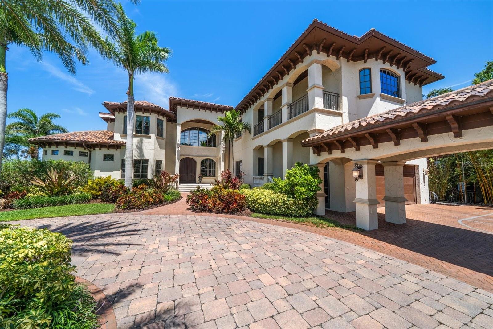 An estate where two elite worlds collide- WATERFRONT luxury & EQUESTRIAN prestige. Tucked away behind a canopy of majestic oaks, a winding Tennessee fieldstone driveway leads you to a Mediterranean-inspired masterpiece that redefines elegance and luxury. Crafted by renowned Brandon Construction, this private estate is a true tropical paradise, created for those with the most discerning taste. Custom double entry doors open to an awe-inspiring interior—where sophistication and thoughtful design meet. The private office offers quiet productivity, while the breathtaking living and dining room commands attention with soaring floor-to-ceiling windows that perfectly frame the resort-style pool and lush outdoor living areas. The chef’s kitchen is the heart of the home, featuring granite countertops, a center island with prep sink, breakfast bar, pot filler, custom built-in Miele fridge & freezer, gas cooktop, and a walk-in pantry—all open to a warm and spacious family room with beamed coffered ceilings, a cozy fireplace, and sliders to the outdoor oasis. Every detail has been considered, from the pool bath, mudroom, and laundry room to the theater room with stage and stadium seating—ideal for movie nights or performances. The primary suite is a serene retreat, flooded with natural light and accented by rich wood beams, a jaw-dropping custom walk-in closet with center island, and a spa-like bath with jetted tub, double walk-in shower with triple heads, dual vanities, a dressing table, and a hidden passage to the home office. Additional bedrooms and bathrooms are designed to pamper family and guests alike. Step outside and you’re transported to your own luxury resort—complete with a two-level heated pool and spa, outdoor kitchen, fireplace, and multiple entertaining areas. For boating enthusiasts, a TREX dock with a 10,000 lb lift offers direct access to the Intracoastal, while west-facing views provide spectacular sunsets that melt into the Gulf. But the crown jewel of this estate may be its custom-built barn—featuring rubber paver flooring, stalls with custom cushion mats, a tack room with custom saddle racks, feed room, covered and lit riding arena for nighttime rides, and a loft with full kitchen and bath, perfect for an on-site trainer or in-law suite. Spring-fed streams weave through the grounds, adding a touch of magic to this must-see property. Overlooking the Narrows and nestled in nature yet minutes from shopping, dining, and the beach—this is more than a home; it’s a once-in-a-lifetime opportunity to live your dream.