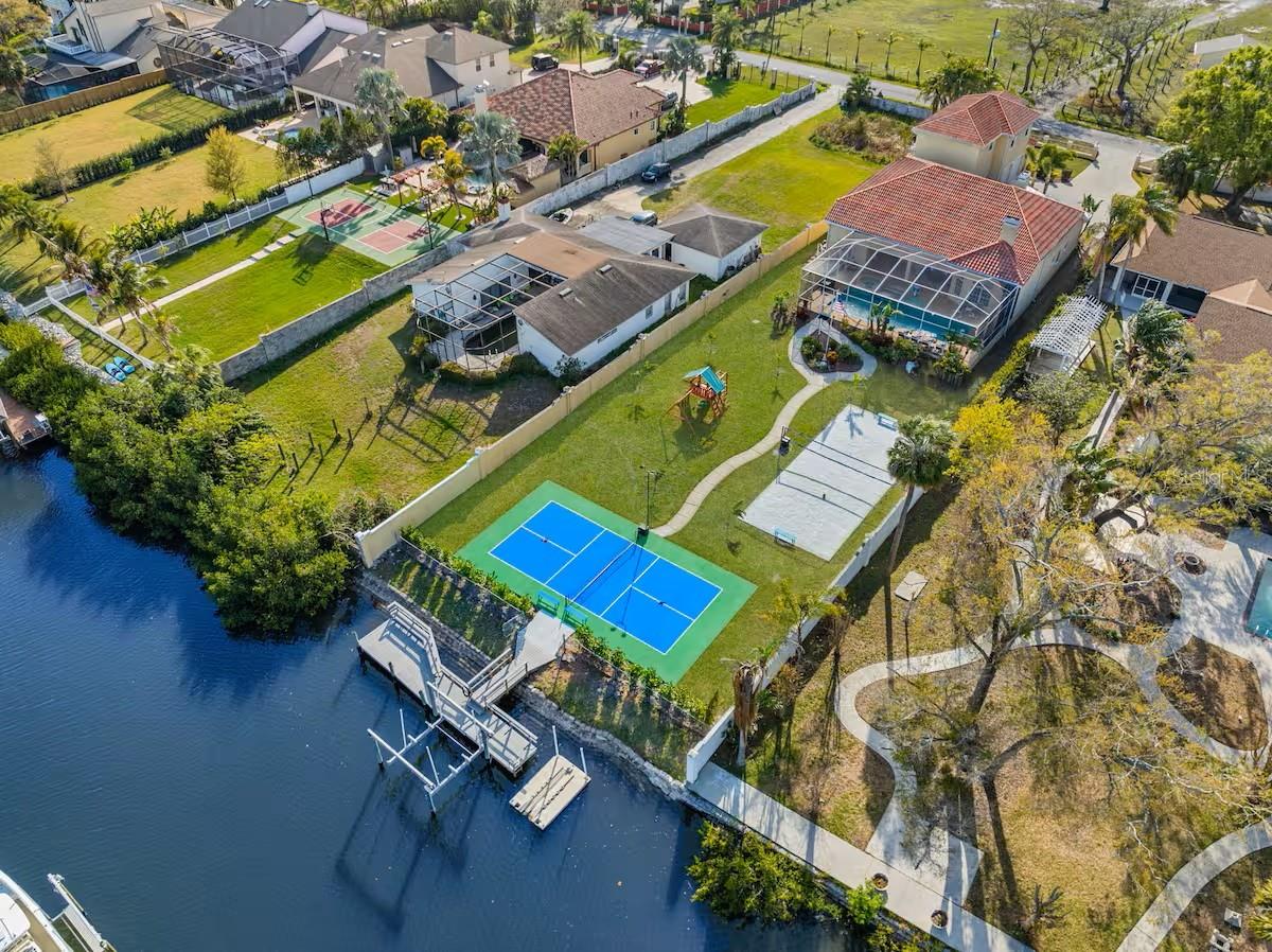 This expansive 6-bedroom, 4.5-bathroom waterfront home is the ultimate retreat for families or large groups, comfortably accommodating up to 16 guests. Nestled in a serene waterfront location, this home is a haven of relaxation, entertainment, and luxury, offering modern comfort and outdoor fun. Fantastic upper-level game room suite with billiard table and other games, two sleeper sofas and a fully stocked kitchen/bar area of its own! Balcony with seating right off the game room.
The space
Plenty of fun with all the amazing outdoor amenities, including a professional size pickleball and volleyball court. Also enjoy the fully equipped backyard playground. Whether you’re planning a family reunion, a friends’ vacation, or a celebration, this property has everything you need for an unforgettable stay.
Price DOES'NT include utilities (water, electricity), pool/ landscape maintenance. The house is also available for seasonal rental.
Highlights: Heated Pool and Jacuzzi, Pickleball Court, Volleyball Court, Game Room Suite, Outdoor Playset, Fire Table, Boat Dock on Canal