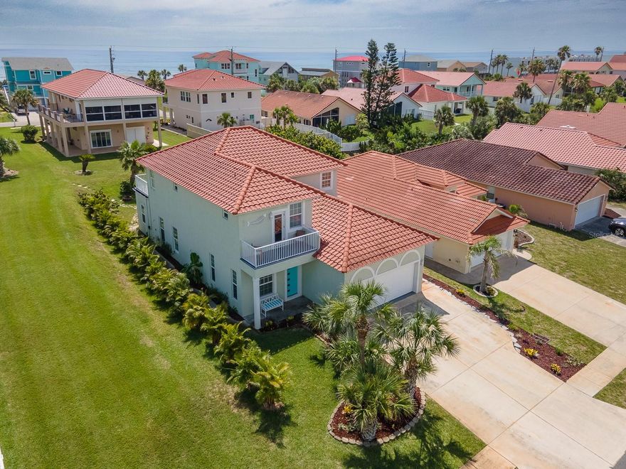One or more photo(s) has been virtually staged. FLAGLER BEACH GEM just 2 blocks from the Ocean with lovely park and both Ocean and Intracoastal Waterway views! Located in an intimate, small HOA community in a no flood X zone, this home is nestled on a peaceful avenue across from a park within steps to a lovely well maintained small dock. The location of this magnificent 4 bedroom, 4 bath home welcomes your family and friends to the beach lifestyle. Sunrise with your toes in the sand, the sound of waves crashing, and soothing, salty air is just steps away. Take your bike or golf cart for a short ride to all that Flagler Beach has to offer – unique eateries and shops, the Pier and beach boardwalk, parks and trails. Swim and socialize with your neighbors and friends in the private community pool. Stepping inside this home, the quality construction is evident. A welcoming entrance opens onto a spacious open plan with high ceilings and abundant windows bringing in the light. The living space with built-in shelving holds an electric fireplace and entertainment essentials. A beautiful bay window at the dining area offers a pretty garden view and adds more light to the kitchen. The kitchen is outfitted with an induction cooktop, granite countertops, an island, a bar and ample cabinets – making every day meal preparation a pleasure and entertaining a breeze. An enclosed patio plus a bonus room and a full bath complete the ground floor. Climb the lovely wood staircase to the second floor to find a primary suite that includes a luxurious ensuite bath, a large walk-in closet and a sizeable balcony with an ocean view. The second bedroom with an ensuite bath has a balcony overlooking the park and the Intracoastal Waterway. The third and fourth bedroom share a Jack-n-Jill full bath. A dedicated laundry room is conveniently located on this floor. A deep, 2 car garage entered from the kitchen has plenty of room for a workshop, a golf cart and beach gear while offering a convenient entrance to bring your shopping in. A whole house generator plug-in and impact windows offer peace of mind along with 2 Trane AC units and hot water heater installed 2023. This home is located in a low-cost HOA which includes a private community pool and landscape maintenance. Flagler Beach is just 3 miles from I-95, located midway between historic St Augustine and vibrant Daytona Beach. Schedule your private viewing today and start making memories in this fabulous, friendly beach town.