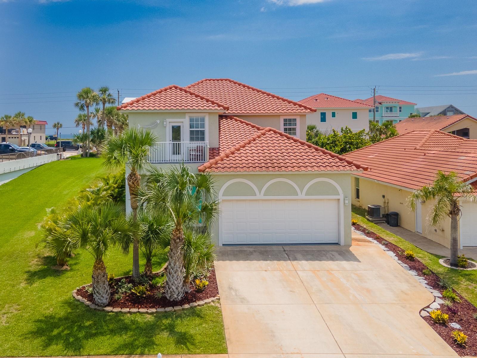 FLAGLER BEACH GEM just 2 blocks from the Ocean with lovely park and both Ocean and Intracoastal Waterway views! Located in an intimate, small HOA community in a no flood X zone, this home is nestled on a peaceful avenue across from a park within steps to a lovely well maintained small dock. The location of this magnificent 4 bedroom, 4 bath home welcomes your family and friends to the beach lifestyle. Sunrise with your toes in the sand, the sound of waves crashing, and soothing, salty air is just steps away. Take your bike or golf cart for a short ride to all that Flagler Beach has to offer – unique eateries and shops, the Pier and beach boardwalk, parks and trails. Swim and socialize with your neighbors and friends in the private community pool. Stepping inside this home, the quality construction is evident. A welcoming entrance opens onto a spacious open plan with high ceilings and abundant windows bringing in the light. The living space with built-in shelving holds an electric fireplace and entertainment essentials. A beautiful bay window at the dining area offers a pretty garden view and adds more light to the kitchen. The kitchen is outfitted with an induction cooktop, granite countertops, an island, a bar and ample cabinets – making every day meal preparation a pleasure and entertaining a breeze. An enclosed patio plus a bonus room and a full bath complete the ground floor. Climb the lovely wood staircase to the second floor to find a primary suite that includes a luxurious ensuite bath, a large walk-in closet and a sizeable balcony with an ocean view. The second bedroom with an ensuite bath has a balcony overlooking the park and the Intracoastal Waterway. The third and fourth bedroom share a Jack-n-Jill full bath. A dedicated laundry room is conveniently located on this floor. A deep, 2 car garage entered from the kitchen has plenty of room for a workshop, a golf cart and beach gear while offering a convenient entrance to bring your shopping in. A whole house generator plug-in and impact windows offer peace of mind along with 2 Trane AC units and hot water heater installed 2023. This home is located in a low-cost HOA which includes a private community pool and landscape maintenance. Flagler Beach is just 3 miles from I-95, located midway between historic St Augustine and vibrant Daytona Beach. Schedule your private viewing today and start making memories in this fabulous, friendly beach town.