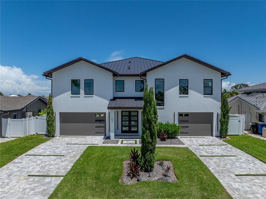 Timeless clean line architecture meets luxury waterfront contemporary Italian design with this 2022 custom built home in the charming community of Yacht Club Estates.  The foyer welcomes you with modern elegance, leading past a striking accent wall and a glass-enclosed wine display room toward the staircase to the main living area.  The main floor offers fabulous water views with its open concept and access to the upper lanai. You’ll notice top line finishes throughout with light-filled living spaces including a chef’s kitchen outfitted with Miele gas range/oven convection combination with upgraded range hood, Miele refrigerator, microwave drawer and undercounter beverage refrigerator.  The solid wood custom cabinets pair perfectly with the expansive center island which is ideal for casual gatherings and entertaining guests. As you move through the living and dining areas the inviting lanai awaits with solid wood tongue and groove ceilings, designer lighting fixtures and views of the heated saltwater infinity edge pool/spa with over 2000 sf of exotic travertine and turf landscaping design.  Steps away, the composite oversized dock boast electricity, solar uplighting and running water.  The primary bedroom is a calming oasis with lovely water views, access to the lanai and large custom closet. The stunning bath area showcases a free-standing tub and enhanced double walk-in shower all elegantly designed as a spa environment.  Three additional bedrooms include custom closets and designer lighting.  Downstairs highlights a car collector’s dream garage with parking for up to 10 prized cars or an incredible flex activity area with French doors leading to the lower lanai with the resort style pool. The home also includes Restoration Hardware designer chandeliers and recessed lighting on dimmers throughout, separate laundry room, tankless water heaters, Sonos system w/all existing Smart TVs, battery powered BLINK camera system, irrigation system and outdoor corner motion detector security lighting.  The location couldn't be better with world famous pristine beaches nearby and the vibrant downtown St Petersburg, just a 20 minute drive away, offers enticing dining, museums, entertainment experiences and professional baseball and soccer teams. This tranquil residence with its exquisite sunset views offers the ideal blend of elegance, and waterfront living for the lifestyle you desire.