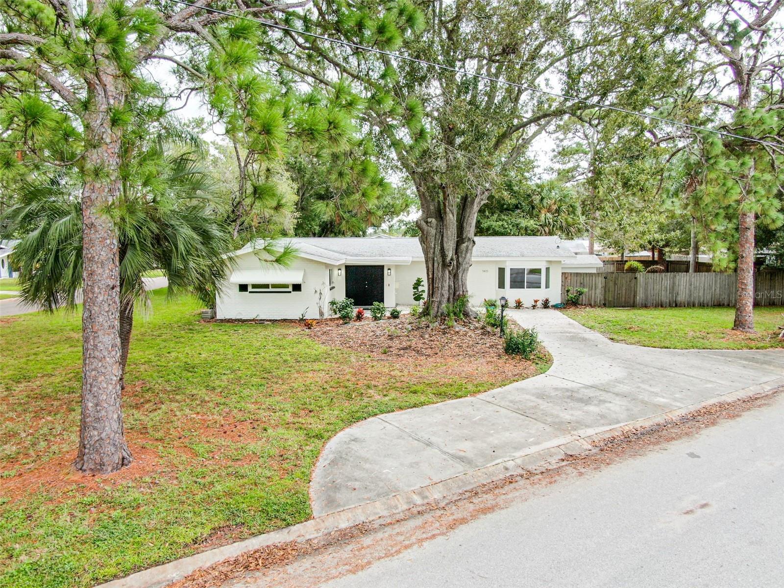 Discover the perfect blend of style, comfort, and functionality in this beautifully updated open-concept home, ideally situated on a rare double corner lot. Featuring 3 bedrooms and 3 full baths, this home boasts easy-care luxury vinyl plank flooring throughout and impact-rated windows for peace of mind. Step inside and prepare to be wowed. The bright and airy living room flows seamlessly into a stunning Florida room, surrounded on three sides by a massive wall of impact glass that fills the space with natural light. From there, step out onto your covered patio and spacious fenced backyard—an entertainer’s dream and a true haven for enjoying the Florida lifestyle. The oversized, updated kitchen is a chef’s delight, featuring stainless steel appliances, a large granite cooking island, and views into both the living and Florida rooms—perfect for hosting and everyday living. The third bedroom is currently set up as a den or office and includes its own ensuite bath with direct access to the backyard, making it ideal for guests or outdoor gatherings. Located in a quiet neighborhood just blocks from the vibrant 4th Street corridor, you'll enjoy quick access to shopping, dining, and all that downtown St. Pete has to offer.
