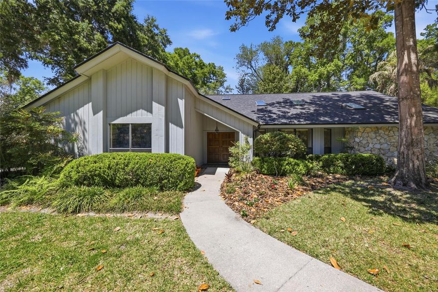 Welcome to Raintree, one of Gainesville’s most established and centrally located neighborhoods—just minutes from shopping, dining, the University of Florida, and top-rated schools.

Situated on a generous 0.43-acre lot, this 2,611-square-foot pool home offers 3 bedrooms, 3 bathrooms, and a spacious screened lanai, all surrounded by a beautifully fenced backyard with mature landscaping.

As you enter through the double solid wood front doors, you’re welcomed by a gracious foyer that opens to a formal living and dining area to the right. Straight ahead, a striking natural stone gas fireplace anchors the expansive family room, which flows seamlessly into the eat-in kitchen. The kitchen features newer stainless steel appliances, vaulted ceilings, and skylights that fill the space with natural light.

Designed for both comfort and accessibility, the home features no carpet throughout and was originally built with handicap-accessible elements, including a garage ramp for easy entry. Four sets of sliding glass doors create a strong indoor-outdoor connection, bringing in abundant light and offering direct access to the pool and lanai.

The primary suite is a true retreat, complete with vaulted ceilings, private pool access, a large walk-in closet, and an ensuite bathroom featuring dual sinks, generous cabinetry, and a spacious walk-in shower with grab bars and a built-in bench. The two additional bedrooms are well-appointed, each with access to their own bathroom—one with a tub/shower combination and the other with a walk-in shower.

Recent updates provide peace of mind, including a new roof (2022) and a resurfaced (re-marcited) pool (2023). Combined with its functional layout, accessibility features, and prime location, this home offers a rare opportunity in the heart of Gainesville.