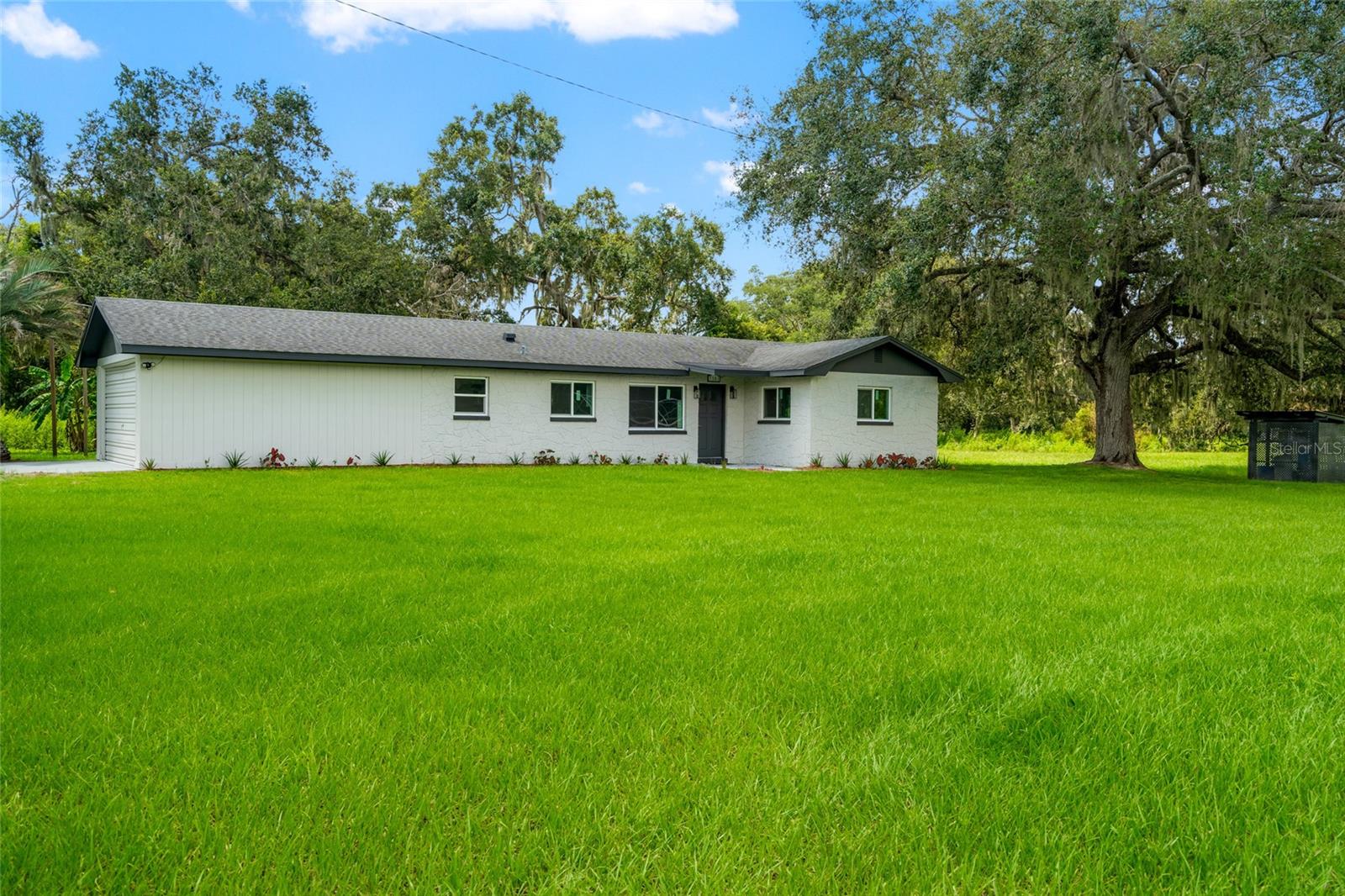 10 ACRES of Country Class, Modern Comfort and MINI FARM Living in Plant City, FL If your dream is to wake up to the sound of roosters, pick fruit from your own orchard, sip coffee on a breezy porch, and still be within minutes of I-4, welcome home. This 3 bedroom, 2 bath block ranch estate on 10 ACRES delivers modern upgrades, endless agricultural potential, and the perfect setup for a thriving mini farm plus a picturesque creek on the property, adding both beauty and utility. Inside the Home? Freshly updated from top to bottom, this home blends rustic charm with modern convenience. HURRICANE GRADE IMPACT ENERGY EFFICIENT SLIDER WIDNOWS fill the home
with light while keeping energy bills low. The open concept floor plan flows through the living, dining, and kitchen areas, perfect for hosting family gatherings or neighborly potlucks. The farmhouse-inspired kitchen is a showstopper: soft-close white SHAKER CABINETS with two lazy Susans for maximum storage, sleek GRANITE countertops with matching backsplash, a deep stainless steel sink with a black gooseneck faucet, and a brand NEW dishwasher and microwave, Kenmore stove and fridge complete the setup. Bathrooms sparkle with granite tops, floor-to-ceiling tile showers and matte black fixtures. Luxury laminate plank flooring runs throughout, while the garage boasts a durable EPOXY FLOOR for easy clean-up after market days or farm projects. Practical, Modern Upgrades: ROOF 6 YEARS OLD, NEW AC/HEATING SYSTEM, NEW WATER HEATER, FRESH INTERIOR AND EXTERIOR PAINT, Maytag metallic slate washer/dryer, GENERATOR manual transfer switch for home backup Outside is Your own Mini Farm, Your Way. Whether your heart is in horse boarding, hobby farming, or farm-to-table entrepreneurship, this land is ready for it all. 9-Stall STABLE, needs some TLC, is Ideal for boarding horses or your own herd. Large open area for equipment storage. Two GREENHOUSES (1,700 sq ft total), Perfect for specialty crops, seed starting, or year-round growing, TLC needed. CHICKEN COOP for Fresh eggs/ STORAGE SHED 20 X 10, ready for tools and feed. RV/CAMPER HOOKUP , ORCHARD & GARDENS, The land is already PRODUCING A FRESH VARIETY OF FRUITS: avocado, mango, citrus, papaya, peach, pomegranate, banana, blueberries, muscadine grapes, and pineapples. Imagine selling your own fresh produce at local markets, supplying nearby restaurants, or simply stocking your pantry with homegrown goodness. Lifestyle Opportunities are endless, Equestrian, Board horses, train, or host riding lessons. Agriculture, Sell produce, run a CSA, or cultivate flowers and specialty crops in the greenhouses. Events, Host goat yoga, farm tours, seasonal festivals, or farm-to-table dinners by the CREEK under the stars. Self-Sufficiency, With a well, septic, orchard, and greenhouses, you can live largely off the land. Rental Income, Use the stables, greenhouses, or land as income avenues. Just 3 miles from I-4, this property offers the perfect combination of rural tranquility and easy access to urban amenities. Whether your seeking a peaceful retreat, an idyllic homestead, or simply a place to call home, this property delivers it all. Welcome to your Florida Paradise.