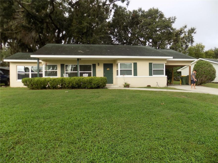 Well priced 2 bedroom home with bonus room that could easily be used as 3rd bedroom.  Water views from most rooms as well as from the rocking chairs perfectly situated on the full front porch.  Wood laminate flooring throughout the kitchen and living rooms give a seamless flow.  Open and bright with spectacular Lake Griffin views across the street.  Freshly painted, oversized bedrooms with blinds.  Open eat in kitchen with breezes and views of the lake.  Bonus room off living room can easily be used as a 3rd bedroom (it's current use).  This room is cheery with views of the lake.  En suite bathroom and walk in closet only add to the appeal of the primary bedroom.  Laundry room enclosed off of carport.  Quiet neighborhood, parks and nature trail nearby.