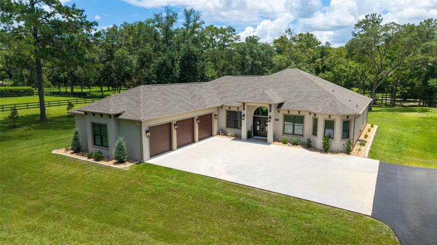 Welcome to this beautifully designed 2022 custom home, nestled on 7.33 private acres in The Village at Hidden Lakes, a gated equestrian community where deer and turkey often wander through the yard and peaceful mornings start with nature right outside your window. This is one of the largest lots in the neighborhood, offering the perfect combination of tranquility, privacy, and potential for your dream farm or country retreat.
 As you arrive, an automatic iron gate opens to a winding asphalt driveway, leading you beneath scattered oaks and past lush, green grass to the front entrance. The home is thoughtfully set back on the property, framed by mature trees and beautifully landscaped with river stone accents. Whether you plan to bring horses or simply want room to breathe, this property delivers the lifestyle you’ve been dreaming of.

Step inside and you’ll immediately appreciate the open, inviting floor plan designed for both comfortable living and effortless entertaining. With 2,597 square feet of living space, this home feels bright and airy, thanks to expansive Pella windows that fill the home with natural light. The living room features wood-look tile throughout, and a stunning floor-to-ceiling stacked stone gas fireplace with a remote thermostat, elevated hearth, and custom mantle—perfect for cozy evenings at home. The main living space also includes a dedicated area for your dining room table, allowing for seamless gatherings and family meals.

The chef’s kitchen is a standout, complete with soft-close custom cabinetry, granite countertops, a gas cooktop, stainless steel appliances, and a coffee station with extra cabinetry and counter space. An oversized kitchen bar is perfect for casual breakfasts, while a separate dining nook overlooks the backyard, creating the perfect spot for morning coffee with a view.

A private office with French doors is located just inside the home near the main living area, offering a quiet space to work from home without sacrificing convenience or flow.

The split floor plan provides privacy for family and guests. The master suite is tucked away on one side of the home, featuring double closets and a spa-style bath with dual vanities, a deep modern soaking tub, and a walk-in tiled shower. On the opposite side, two guest bedrooms share a beautifully finished bath.

An additional half bath and a well-appointed laundry room with cabinet and counter space are conveniently located near the 1,006 sq ft 3-car insulated garage, complete with insulated doors for comfort and efficiency. All interior doors are 36” wide, making the home handicap accessible, and 10’ ceilings with 11’ tray accents add a sense of space and light throughout.

French doors lead from the living room to the covered back porch, where you’ll find a ceiling fan and TV hookup—the perfect place to unwind in the evenings while watching the local wildlife. From here, step into the expansive backyard where you can easily add barns or pastures to create your own horse farm, or simply enjoy the serene, park-like setting with scattered oaks and lush grass.

A storage shed is included for yard equipment, and a list of select furniture is available for purchase with the home.

Conveniently located just 20 miles to I-75, 19 miles to the World Equestrian Center, 9 miles to HITS, 7 miles to Williston, 26 miles to Gainesville, and 20 miles to Ocala, this is the perfect blend of luxury living, rural charm, and modern comfort.