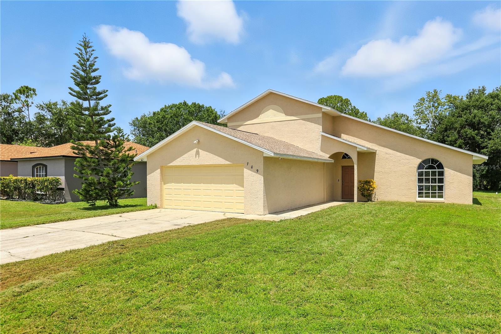 Welcome Home to this beautifully updated 3-Bedroom Gem in Poinciana Villages! Don’t miss this incredible opportunity to own a fully MOVE-IN READY home tucked away in a peaceful cul-de-sac in the heart of Poinciana. This charming two-story, 3-bedroom, 2-bath single-family home has been thoughtfully updated from top to bottom. As you arrive, you’ll appreciate the fresh exterior paint, NEW roof (2024) and brand-NEW HVAC system (2025). Step inside to a light and airy open floor plan featuring gorgeous new luxury vinyl flooring throughout the first floor and brand-new carpet in all bedrooms. Freshly painted interior walls give the home a clean, modern feel throughout. The spacious living room features soaring ceilings 17 feet tall, filling the space with natural light and offering relaxing views of the expansive ¼+ acre backyard, framed by mature trees—perfect for gatherings or peaceful evenings outdoors. Upstairs, enjoy your own retreat in the generously sized primary suite complete with a walk-in closet and private en-suite bathroom. Two additional bedrooms are located downstairs, offering flexibility and privacy for family or guests. The guest bathroom has been updated with white shaker-style cabinets, luxury vinyl flooring, a shower/tub combo and a quartz single sink vanity with extra counter space. The kitchen has been fully upgraded with brand-new shaker-style cabinets, quartz countertops, and stainless steel appliances including a range, microwave, dishwasher, and NEW refrigerator—perfect for cooking and entertaining! Additional highlights include an indoor laundry room, a fully repainted garage, and a NEW water heater (2024) for added comfort and efficiency. Enjoy the Florida lifestyle with access to resort-style community amenities through the Poinciana Villages Association, including a fitness center, multiple swimming pools, playgrounds, trails, dog parks, and more! Plus, the low HOA fee includes internet and cable! Welcome Home!