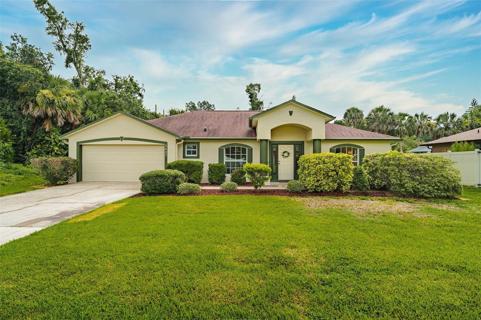 Move-in ready and no HOA! Welcome to this bright and inviting 3-bedroom, 2-bath home offering 2,020 square feet of living space on nearly a quarter-acre lot. Freshly painted inside and out, this home is filled with natural light and begins with flexible living and dining areas featuring charming arched windows and pendant lighting—ideal for entertaining or quiet evenings in. The open-concept kitchen and family room sit at the heart of the home, showcasing rich cherry cabinetry, a convenient center island with double sink, a spacious eat-in area, and a large closet pantry. Natural light pours in through brand-new sliding glass doors, creating a seamless flow to the private backyard oasis. Tucked away for privacy, the primary suite includes a walk-in closet and an ensuite bath with a relaxing soaking tub and separate shower. On the opposite side of the home, two additional bedrooms and a second full bath provides comfortable space for family or guests. A spacious indoor laundry room adds everyday convenience. Additional highlights include a 2021 A/C, hurricane shutters, and an irrigation system—all just minutes from New Smyrna Beach, with easy access to shopping, dining, parks, boat ramps, and I-95.
