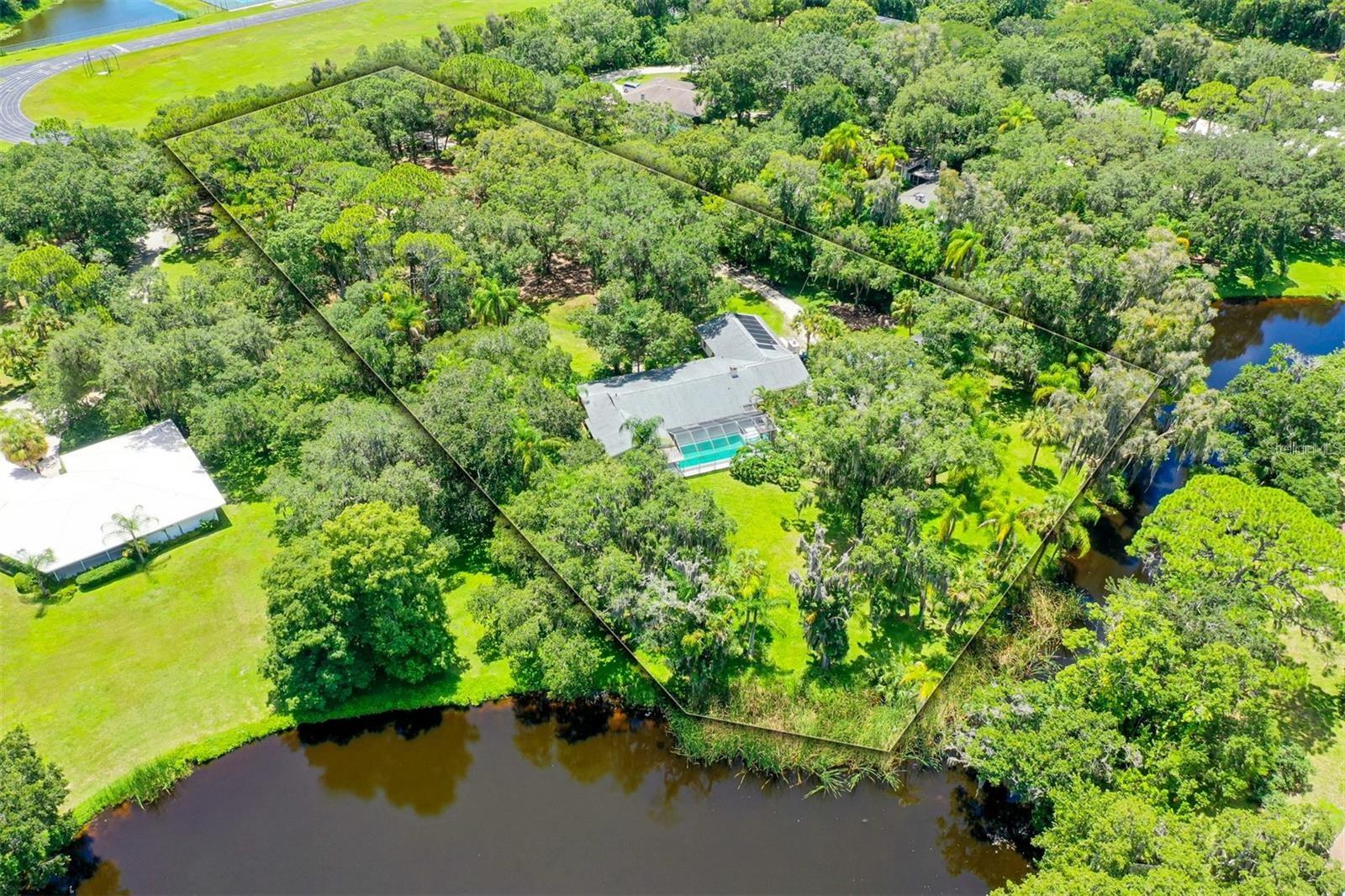 PRICE IMPROVEMENT ON 4576 Cooper Rd! Over 2 acres with serene lake views IN TOWN! Sprawling 5 bedroom home with additional 1 BEDROOM 1 BATH DETACHED HOUSE. Old Florida vibes creep in as you pull down this private road and into this secluded retreat. A long, driveway unwinds under a Live Oak and Cabbage Palm canopy. Imagine having the space and privacy of "east county acreage" but with the absolute convenience of being minutes from everything and NO HOA!! Bring all of your toys because not only do you have the space, but there's also no rules to state otherwise. Home has a partial kitchen remodel, one bathroom remodel, and the addition of two bedrooms. A sparkling pool and lovely lake views are yours through the expansive bank of sliders visible from almost every room. The additional 1/1 home on the property is perfect for multi-generational living, an office, an art studio, or rent it out for extra income. Live the homesteading life of your dreams with plenty of sunny space for your vegetable garden and a coop full of chickens that convey if you'd like!
So many things to say about this rare property, that it's best to see for yourself! Professional photos coming soon.