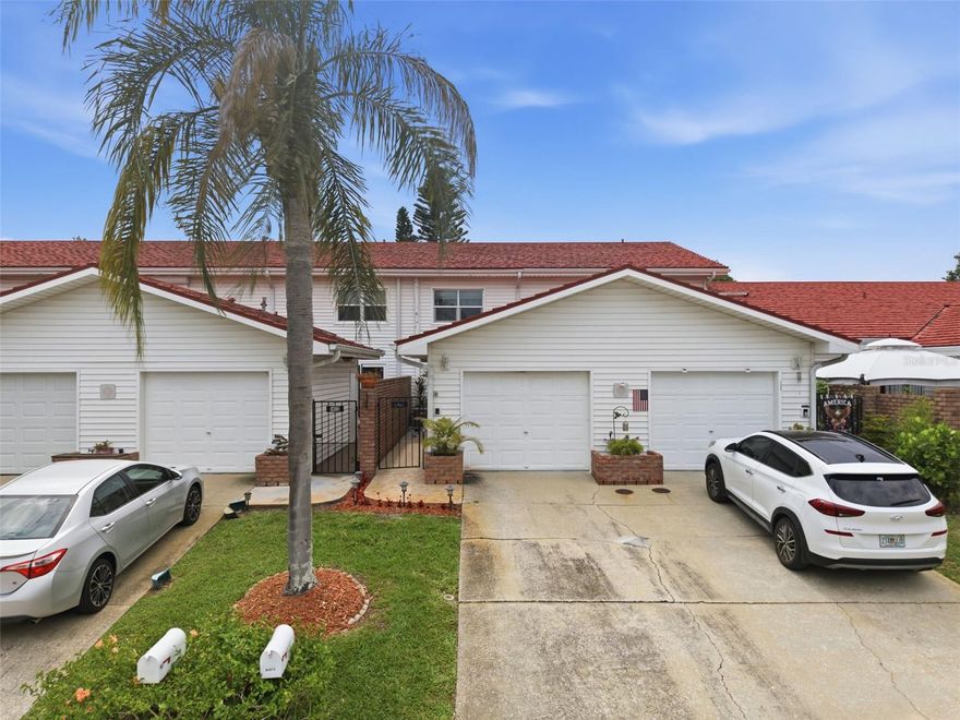 One or more photo(s) has been virtually staged. Water views, private outdoor spaces, meaningful upgrades, and a layout that feels anything but ordinary — this beautiful 2-bedroom, 2.5-bath townhome with a 1-car garage has so much to appreciate.

From the moment you arrive, the home immediately feels special. A gated entry opens into a charming private courtyard, creating a quiet, tucked-away entrance that connects the garage, walkway, and front door in such a unique way. It is the kind of first impression that gives the home character before you even step inside.

Once inside, you are welcomed by a bright and updated kitchen that has been beautifully improved with bright shaker-style cabinetry, stainless steel appliances, a farmhouse-style sink, under-cabinet lighting, a stylish backsplash, and gorgeous light countertops with soft gray veining. The pass-through opening keeps the kitchen connected to the main living and dining area, giving the home an open, comfortable feel that works well for everyday living and entertaining.

The main living space offers plenty of room to relax, gather, and enjoy the natural light coming in from the back of the home. Sliding glass doors lead from the living room to a screened lanai, creating an easy indoor-outdoor flow. From there, the setting only gets better. Step outside to a beautifully manicured backyard area with lush landscaping, a peaceful pond view, and open green space beyond. For a townhome, this outdoor setup is truly something special — you have the screened lanai, the private backyard feel, and the water view all working together to create a quiet Florida retreat.

Upstairs, the layout continues to impress with two spacious bedrooms, each with its own private bathroom. The primary suite offers a calm and comfortable retreat with peaceful views and sliding glass doors that open directly to a large screened balcony overlooking the pond. That balcony is one of the standout features of the home — perfect for morning coffee, reading, fresh air, or simply unwinding while taking in the view. The primary bathroom has also been beautifully updated with a walk-in shower, giving the suite a clean and refreshed feel.

The second bedroom also has its own private bathroom, making it ideal for guests, family, or even a roommate-style setup. This bathroom includes a newer Safe Step walk-in tub with jacuzzi jets, offering comfort, relaxation, and convenience.

Additional highlights include an updated downstairs half bath, crown molding, newer flooring in key areas, a private laundry area, and a community pool nearby. The aerial views show just how nicely positioned this home is, surrounded by water, mature trees, green space, and community amenities.

Centrally located in Largo, you are close to shopping, restaurants, medical facilities, airports, and the Gulf beaches, while still enjoying a peaceful community setting that feels tucked away from the everyday rush.

Between the private courtyard entry, updated kitchen, spacious living area, screened lanai, manicured backyard, pond views, large screened balcony off the primary suite, ensuite bedrooms, garage, and community pool, this townhome delivers far more than expected.

This is not just another townhome — it is a move-in-ready home with charm, upgrades, views, and outdoor living spaces that make you want to slow down and stay awhile.