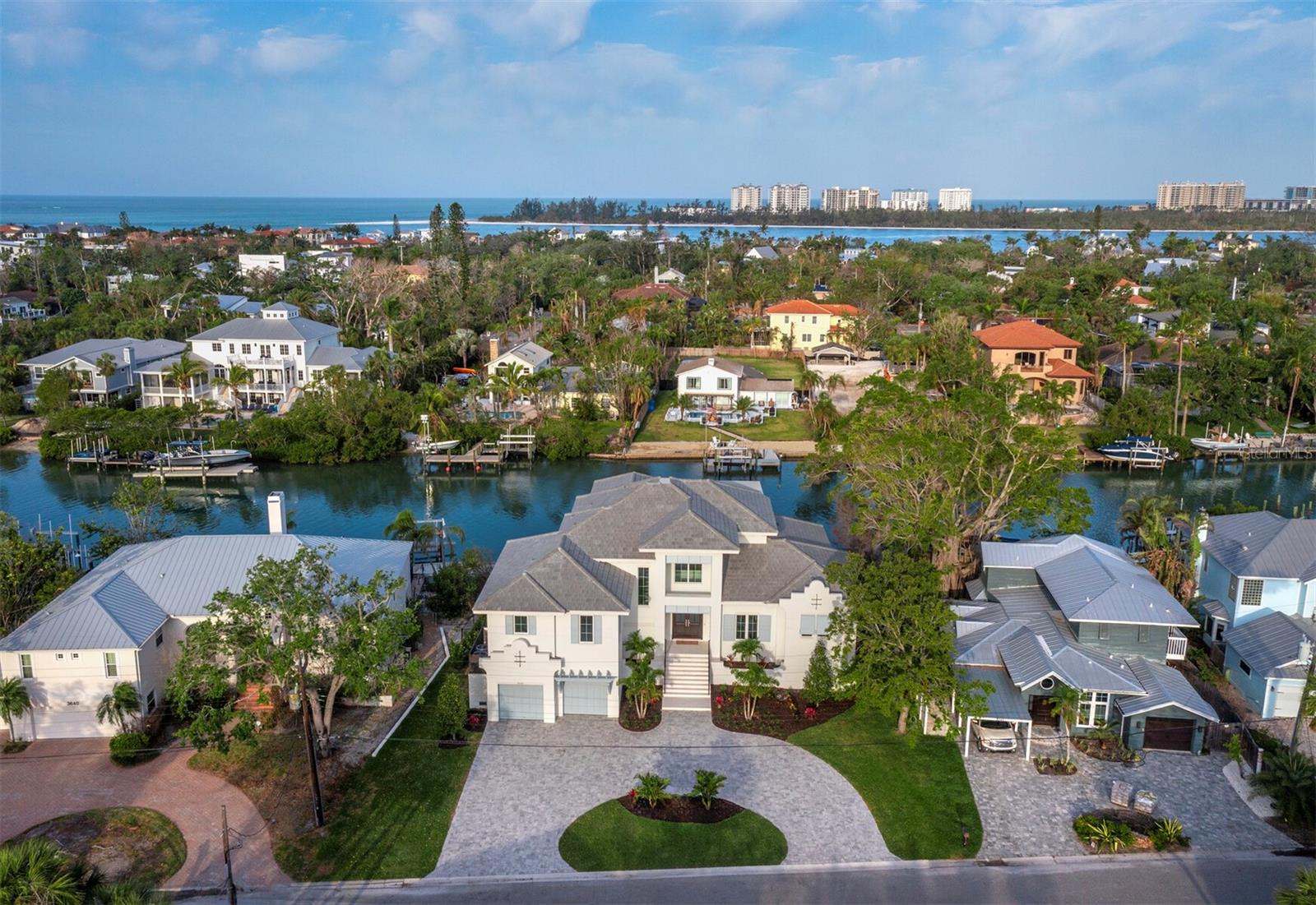 READY FOR OCCUPANCY. CONSTRUCTION COMPLETED. LOWEST NEW CONSTRUCTION price on highly desirable North Siesta Key. Situated on 1/3 acre with 102 feet of wide canal waterfront and no bridges to the bay. The 4,711 square foot home is solid block construction on all levels. The house has been thoughtfully designed, maximizing privacy and use of space. The main level features a designer kitchen with an open floor plan to the great room, a separate office, two covered terraces and a summer kitchen. The spacious primary suite is also on the main level with dual closets and a sumptuous bathroom featuring a large walk in shower and separate soaking tub. Mid level you will find 2 en-suite bedrooms, and the upper level boasts a clubroom with wet bar, a second primary suite, and an outdoor covered terrace to enjoy the sunset views. Other notable features include high ceilings with an abundance of natural light, an elevator to all levels, 3-car garage (one tandem), and a heated saltwater pool & spa. Constructed by premier builder Mike Voigt and interiors by acclaimed designer Angela Rodriguez, this house will check all the boxes of your dream waterfront home. The property was listed pre-construction. The days on market are reflective of the entire construction process and certificate of occupancy was granted end of March 2025.