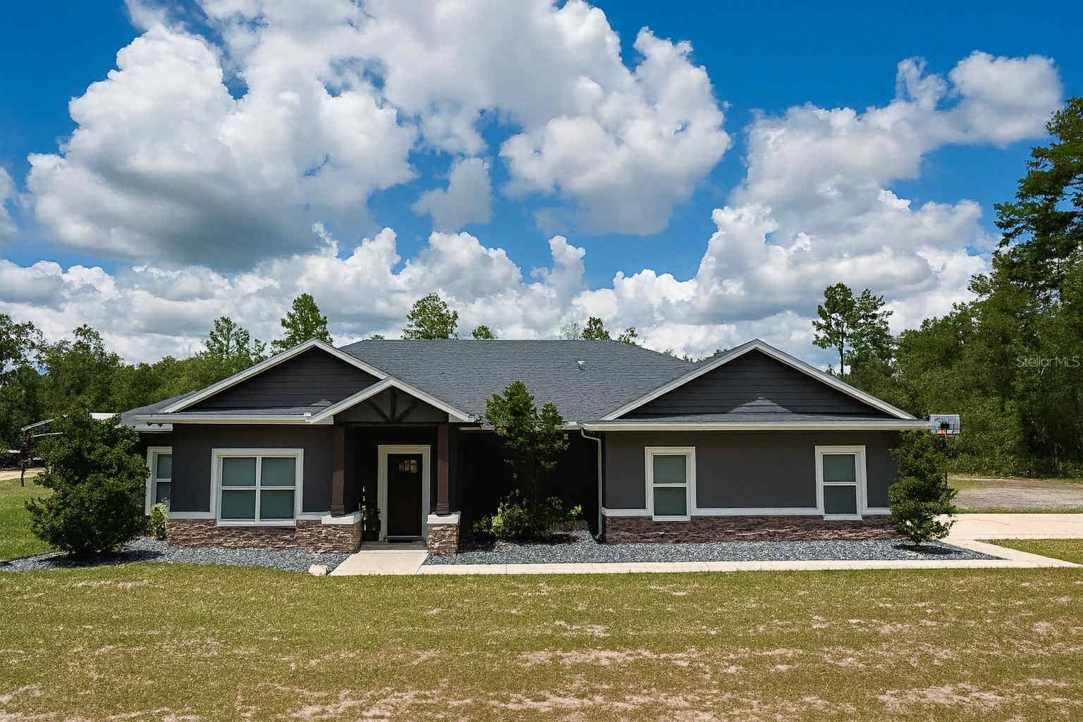 Custom Farmhouse on 3.81 Acres with Barn, Lake Access & Premium Upgrades. Built in November 2021, this 4-bedroom, 2.5-bath custom home offers 2,092 sq ft of luxury living on 3.81 acres of high-and-dry land in Altoona, FL. Just outside the up-and-coming city of Umatilla. Interior Features: • Vaulted ceilings, crown molding & aesthetic barn doors. • Granite countertops throughout. • Under-cabinet lighting + oversized kitchen island with pop-up electrical outlets for convenience and hosting gatherings. • Touchless kitchen sink + built-in mini bar fridge + pot filler. • Custom cabinetry in all rooms and closets with soft close, real solid wood and upgraded features to include oversized drawers, hidden spaces to ensure no wasted space and offer additional storage. • Luxury vinyl plank (LVP) flooring throughout (waterproof). • Smart home tech: built-in Alexa sound system throughout. • Tankless water heater & gas appliance upgrades. • Spacious utility room with built-in dog wash station. Exterior & Outdoor Amenities: • 2,250sq ft custom barn with electric and water with enclosed 2 car size workshop or office space + concrete pad for recreation, storage, or hobbies. • Fire pit lounge with paver surrounding. • Large screened-in patio for entertaining. • Irrigated landscaping + fascia electrical plugs (great for outdoor lighting). • Lake Dorr access—great for boating and fishing. *All appliances will come with the home! • Tranquil setting with deer &turkey regularly roaming the property. A rare opportunity to own a move-in ready, thoughtfully designed farmhouse right in the middle of all of Florida where major cities are a short drive away! Appraisal has been completed on this home prior to listing to ensure accuracy integrity.