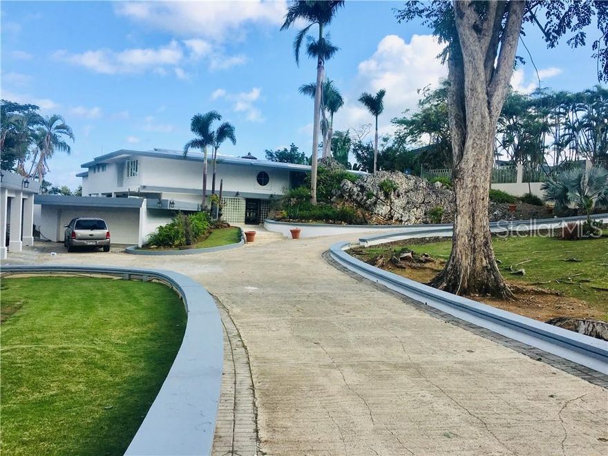 Magnificent estate with panoramic ocean and city views and only 6 miles from San Juan  ,totally  remodeled and expanded with over 7,917 sf of living area and close to 10,000 sf of gross construction area. Enjoy living in this unique  residence with expansive cathedral ceilings in the Grand Room, living, family and dining room and modern  kitchen  that all  opens to an amazing terrace and pool with a cascade.  The covered terrace also has a large wet bar and BarBQ area for outdoor entertaining next to the Jacuzzi and pool  . There's  also  a gazebo that has sweeping views of the San Juan Bay, ocean and metro area. To complete this luxurious house there is a wine cellar , a gym, another family area in the second story, an elevator, a home theater room to watch movies at home, an office, besides the two huge master suites each with his and hers huge walk- in closets and 4 additional bedrooms with en-suite baths, plus a maid's room and a separate laundry room.  There are 5 individual car garages . This  outstanding  property has a 6917.5 s/m fenced lot with an impressive circular car entrance and two electric gates one to  enter and one to exit, a large generator, a  cistern and a beautifully landscape yard with many fruit trees. Tintillo Hills is a double gated community with a 24-hour guard, very safe having it's perimeter surrounded by the Buchanan Base.  By appointment only.