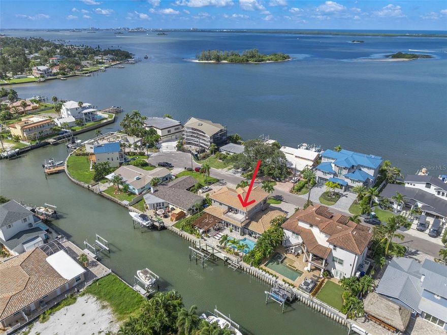 Welcome to 2133 Harbor View Dr in Dunedin FL. Dreams do come true in this stunning luxury waterfront residence located on one of the most desirable streets in Dunedin, one of Tampa Bay’s most sought-after coastal destinations. This beautiful home features 5 bedrooms and 4 full baths. This two-story estate showcases a first-class renovation with soaring 10-foot coffered ceilings, expansive impact-rated windows and doors, a whole-house gas generator, and elegant designer finishes throughout. From the circular driveway, the impressive architecture and welcoming covered entry with solid wood and glass double doors set the tone for what awaits inside. Step into a coastal-inspired open great room designed for Florida living at its finest. The chef’s kitchen is the centerpiece, featuring a large quartz-topped island with bar seating, GE Café appliances including a gas cooktop, under-counter microwave, double convection ovens, and floor-to-ceiling cabinetry. A dry bar with beverage cooler offers added convenience, while the adjoining dining area and living spaces flow seamlessly together. Floor-to-ceiling windows fill the home with natural light and frame views of lush tropical landscaping, the sparkling pool, and tranquil waterfront. The main level includes a primary suite with sliders to the pool deck, custom closet system, electric shades, and a spa-like ensuite bath. Two guest bedrooms with plantation shutters and built-in closets are located across the family room, along with a full bath and laundry facilities. Upstairs, a grand primary suite offers a seating area with built-in cabinetry, French doors to both front and rear balconies, and an ensuite featuring dual vanities, a large walk-in shower, private water closet, and a spacious custom closet. From the rear balcony, enjoy morning coffee overlooking the pool and canal, where dolphin and manatee are often spotted, while evening sunsets can be savored from the front balcony with partial Gulf views. The outdoor living space is designed to impress, with a resort-style pool, fully equipped outdoor kitchen under a lighted pergola, and seating areas perfect for entertaining. Features include a professional-grade grill, seafood boil burner, oversized griddle, beverage fridge, granite counters, storage, and a high-resolution outdoor TV. A beautifully designed full pool bath with shower adds convenience. The newer seawall and maintenance-free dock include a 20K pound boat lift plus a smaller lift for a tender or Jet Ski, offering quick access to the open Gulf waters. Located mins from downtown Dunedin, boating marinas, the Pinellas Trail, golf courses, the Toronto Blue Jays Spring Training ball park, beaches, historic hotels, and Honeymoon Island. Pinellas Trail spans nearly 40 miles, offering scenic biking, walking, and jogging paths that connect charming downtowns like Dunedin, Clearwater, and Tarpon Springs. Mins from Honeymoon Island, one of Florida’s most celebrated beach parks, features pristine white-sand beaches, nature trails, and ferry access to Caladesi Island. Living here means endless opportunities for recreation, relaxation, and soaking up the best of the Florida coastal lifestyle—just mins from your doorstep. Dunedin itself is a charming and vibrant city with a downtown area filled with delicious restaurants and unique retailers. The city offers recreational activities for all ages, historical landmarks, cultural events, & nearly 4 miles of picturesque waterfront. Call today!
