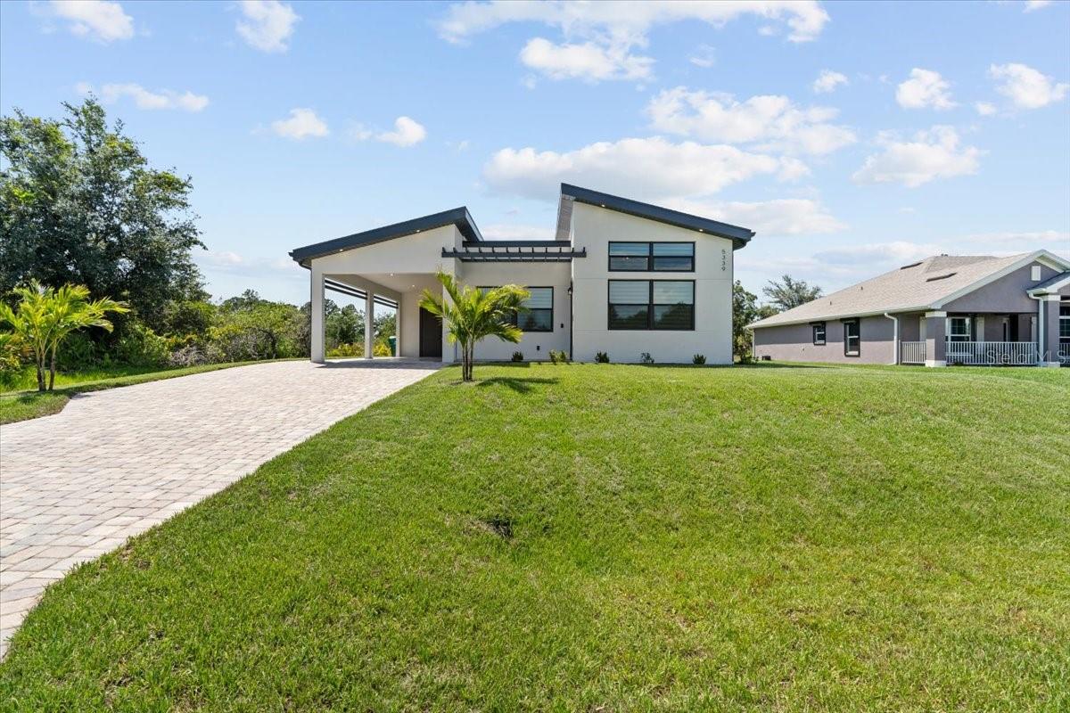 This meticulously crafted, light-filled home combines modern elegance with functional design. Enjoy vaulted ceilings, luxury vinyl plank flooring, and a spacious open-concept layout. The gourmet kitchen features 42" soft-close cabinets, Calacatta quartz countertops, a large island, walk-in pantry, and brand new luxury stainless steel appliances. Two generously sized bedrooms include walk-in closets and ceiling fans, while a versatile bonus room with private entry is ideal for a home office, guest suite, or creative space. The home features elegant modern lighting in the main living spaces that beautifully complements its open design. For added privacy and style, all windows feature double-layer designer shades. Step out to a spacious, covered lanai and generous backyard, perfect for entertaining or relaxing. Located in the desirable Gulf Cove community, offering *voluntary* HOA membership with access to a private boat ramp on the Myakka River—ideal for boating enthusiasts. The area has no deed restrictions, making it perfect for those with RVs or boats. Conveniently located near beaches, golf, shopping, and dining, with easy access to SR-776 and US-41. Additional upgrades include: hurricane-impact windows and doors, 8' interior doors, a 45' paved driveway, and a covered carport with EV charging outlet.