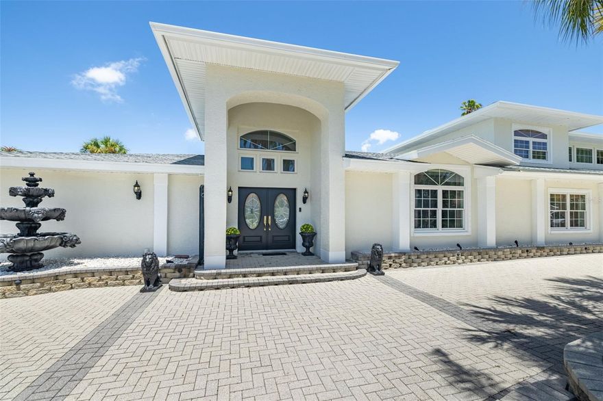 ELEVATED ABOVE THE STREET ON AN EXPANSIVE DOUBLE LOT! This freshly painted Tierra Verde residence offers stately curb appeal, generous scale, large private pool backyard, and outstanding potential. A paved driveway leads to the inviting porch with entry door and continues onto oversized garage and offers ample surface parking—perfect for showcasing a collection of vehicles.
Step into the soaring foyer and discover a home thoughtfully designed for comfort, entertaining, and everyday lifestyle. To the left, a custom theater room seats up to eight. To the right, a private office with built-in closet space and substantial desk easily converts to a fifth bedroom. The open-concept living and family room centers around a stylish wet bar and media wall, flowing seamlessly into a chef-inspired kitchen. Outfitted with dual high-end refrigerators, two dishwashers, a large electric cooktop with chef’s rack, dual sinks, granite countertops, and extensive cabinetry, current dining table seats 12, this kitchen is enormous, functional and impressive.
A wall of sliders ready to entertain open to a fully fenced, completely private backyard oasis featuring a sparkling pool, shaded lounging areas, ambient lighting, and an outdoor kitchen. Low-maintenance landscaping front and back allows effortless enjoyment of the lush island surroundings.
The conveniently located main-level primary suite features custom built-ins, a walk-in closet, and a spa-style bath with Jacuzzi tub, walk-in shower, and smart commode. A guest bedroom and the convertible office complete the downstairs with a nearby half bath. Upstairs, two spacious guest bedrooms are connected by a loft—ideal as a media space, playroom, or kitchenette—along with a stylish full bath and a large walk-in closet/bonus room.
The oversized garage is a standout, offering premium red-and-black craftsman cabinetry, utility sink, ceiling beam for lifting equipment, and space for up to five vehicles. With direct access to the side and rear yard, it’s a dream setup for car collectors or hands-on enthusiasts.
With its exceptional privacy, flexible layout, zero hurricane or flood damage, and generous footprint, this residence offers rare value and opportunity in one of Tierra Verde’s most sought-after island communities—ready for a personalized touch to bring it to its full potential. Roof 2023. Located 10 mins from downtown St Pete, 30 mins to TPA, 10 mins to Ft DeSoto Park & Beaches