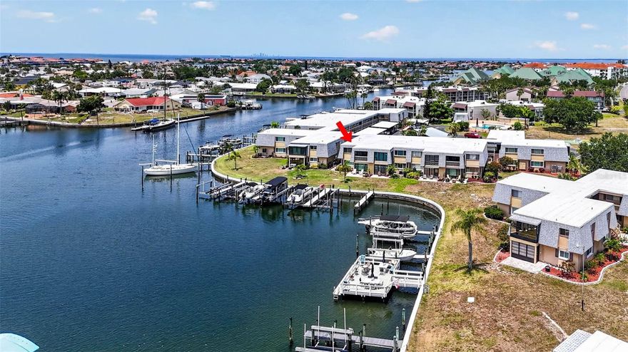 This beautifully upgraded condominium offers direct access to Tampa Bay and the Gulf, showcasing true pride of ownership. Spanning 1,125 sq. ft., this two-bedroom, two-bathroom gem features an airy open floor plan that flows into a spacious living room with stunning views of Lake Sunrise. Step through the sliding glass doors to your private screened patio—the perfect spot for morning coffee and breathtaking sunrises. The home features a remodeled kitchen with elegant light granite countertops, tile flooring, newer appliances and a breakfast bar.  The primary suite is a true retreat, positioned at the rear of the unit to capture water views and featuring a generous walk-in closet. Both bathrooms have been tastefully updated with granite counters, tile flooring and ceramic tile above the tub.  Throughout the home, you'll find crown molding and a coastal-neutral palette that compliments the waterfront setting.  The property is being sold fully furnished, has an assigned carport #206 and has storage in the screened patio area.