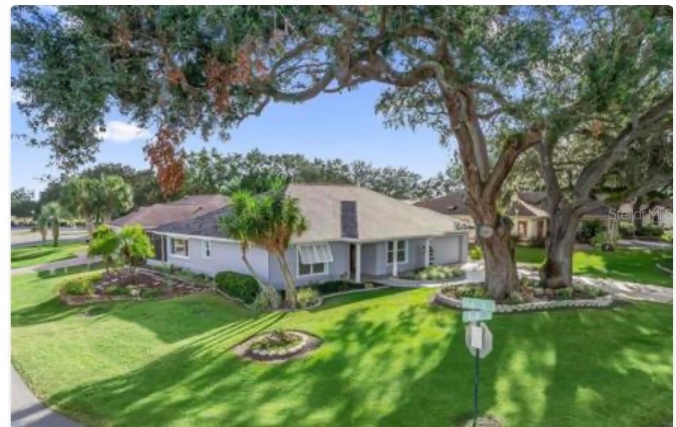 One or more photo(s) has been virtually staged. Beautifully maintained block and stucco home with 1,700 sq ft in the 55+ gated community of Stonecrest, convenient golf cart ride to The Villages, shopping, and medical. Recently PAINTED (2025) inside and out, this well cared for home sits on a shaded CORNER LOT lot with a majestic oak trees, complete with beautiful flowers and garden beds to enjoy. HIGH CEILINGS, openness throughout, and tile and WATER PROOF LUXURY VINYL PLANK flooring will greet you as you enter the home. Updates include a newer roof, upgraded windows, garage door (2019), and appliances (2020). The kitchen features updated cabinets, a tasteful backsplash, a HURRICAN-RATED SKYLIGHT that fills the space with light, and overlooks a serene garden retreat. The versatile OFFICE/CRAFT ROOM offers abundant cabinetry plus 2 closets. The dining room is complete with a BAY WINDOW, and there are 5 UPGRADED FANS/ LIGHTS throughout the home. Both bedrooms have en-suite baths; the primary includes a walk-in and linen closet. Enjoy the enclosed SUN ROOM with heating/cooling, a screened patio with a large ELECTRIC AWNING (2020), and a separate cooled golf cart garage/workshop with storage and the ATTIC offers a fan and additional storage. Wired for a generator and complete with a WATER FILTRATION SYSTEM—this home blends comfort, upgrades, and peace of mind. ROOF December, 2023, HW 2023, HVAC 2007. Start enjoying the pools, dances, clubs, pickleball, and amenities this neighborhood has to offer! Schedule your tour today!