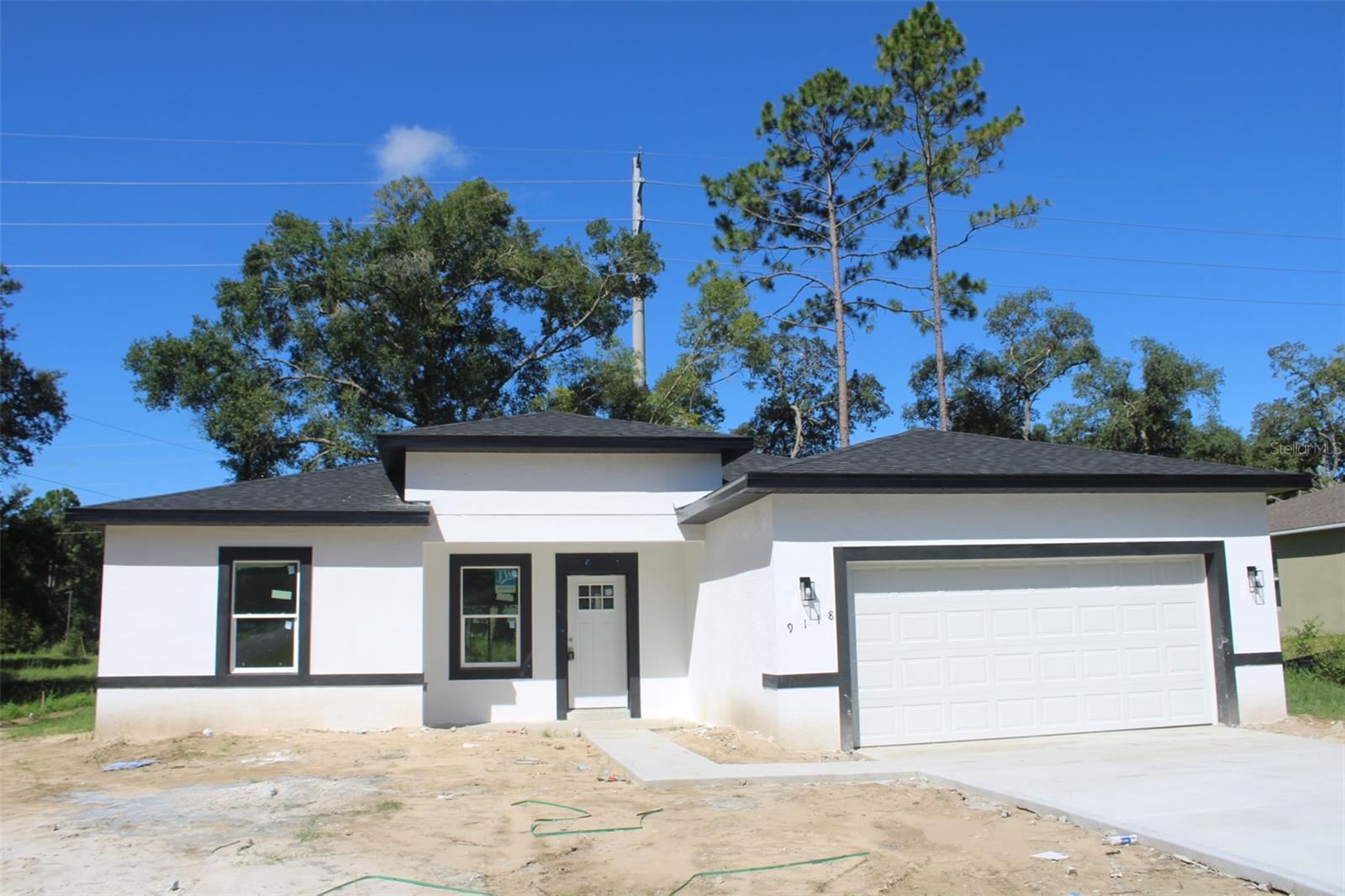 Under Construction. One or more photo(s) have been virtually staged.
Brand-New Home in Citrus Springs – Modern Living with Timeless Charm!
Step into this stunning new construction that combines contemporary design with everyday functionality. From the welcoming front porch to the beautifully landscaped front yard, every detail has been thoughtfully crafted to impress.
This spacious 4-bedroom, 2-bath home offers open-concept living with abundant natural light flowing through large windows and sliding glass doors. The expansive living area creates a warm, inviting atmosphere and flows seamlessly into the outdoor space — ideal for relaxing or entertaining.
Enjoy elegant wood-look vinyl flooring throughout, adding durability and style to every room. All bedrooms feature built-in closets for easy organization, while the primary suite offers a generous walk-in closet and a luxurious bathroom complete with dual sinks and a freestanding soaking tub — your own private retreat.
The kitchen is a true showstopper, boasting quartz countertops, contemporary cabinetry, and quality appliances — ready for your culinary creations. The adjacent laundry room is conveniently located and designed to maximize functionality.
Additional highlights include a 2-car garage with an automatic door for comfort and security, and a 1-year builder's warranty that offers peace of mind.
Located in a growing and desirable section of Citrus Springs, you’ll be minutes away from parks, schools, shops, and more.
Don’t miss your chance to own this beautiful new home. Contact us today to schedule your private showing!