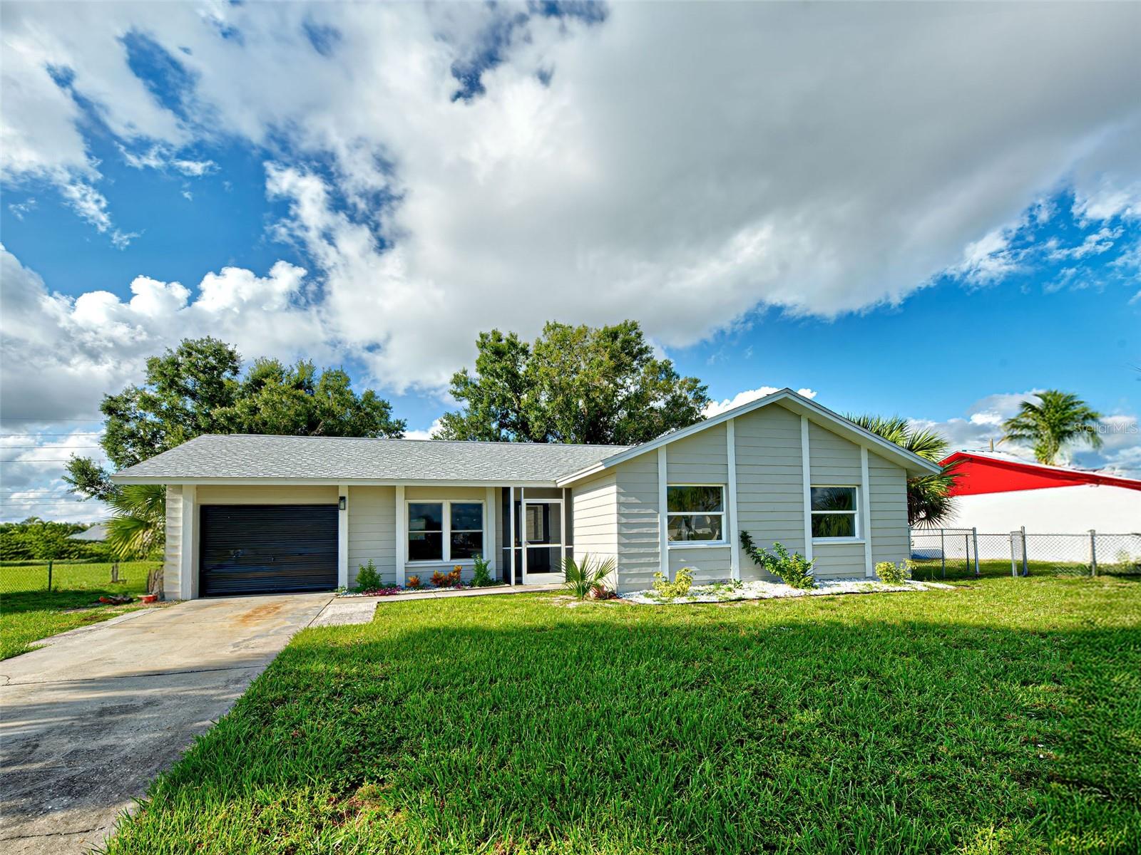 One or more photo(s) has been virtually staged. Step into this beautiful fully renovated 3-bedroom, 2-bathroom home with a versatile flex space, perfectly located in Port Charlotte! From top to bottom, this home has been thoughtfully updated for modern living. The open-concept floorplan is ideal for entertaining, featuring a brand-new kitchen with custom cabinetry, new countertops, and all-new appliances. Enjoy the stylish luxury vinyl flooring that flows throughout every room. The spacious primary suite offers a walk-in closet and a beautifully updated ensuite bathroom. Peace of mind comes with updated windows, and a 2-year-old roof. Freshly painted both inside and out—including the garage, which boasts a new epoxy floor—this home feels fresh, clean, and move-in ready. The landscaped yard is fully fenced with mature trees. Just minutes from the beach, shopping, and dining—this home checks all the boxes. Easy to show—schedule your private tour today!