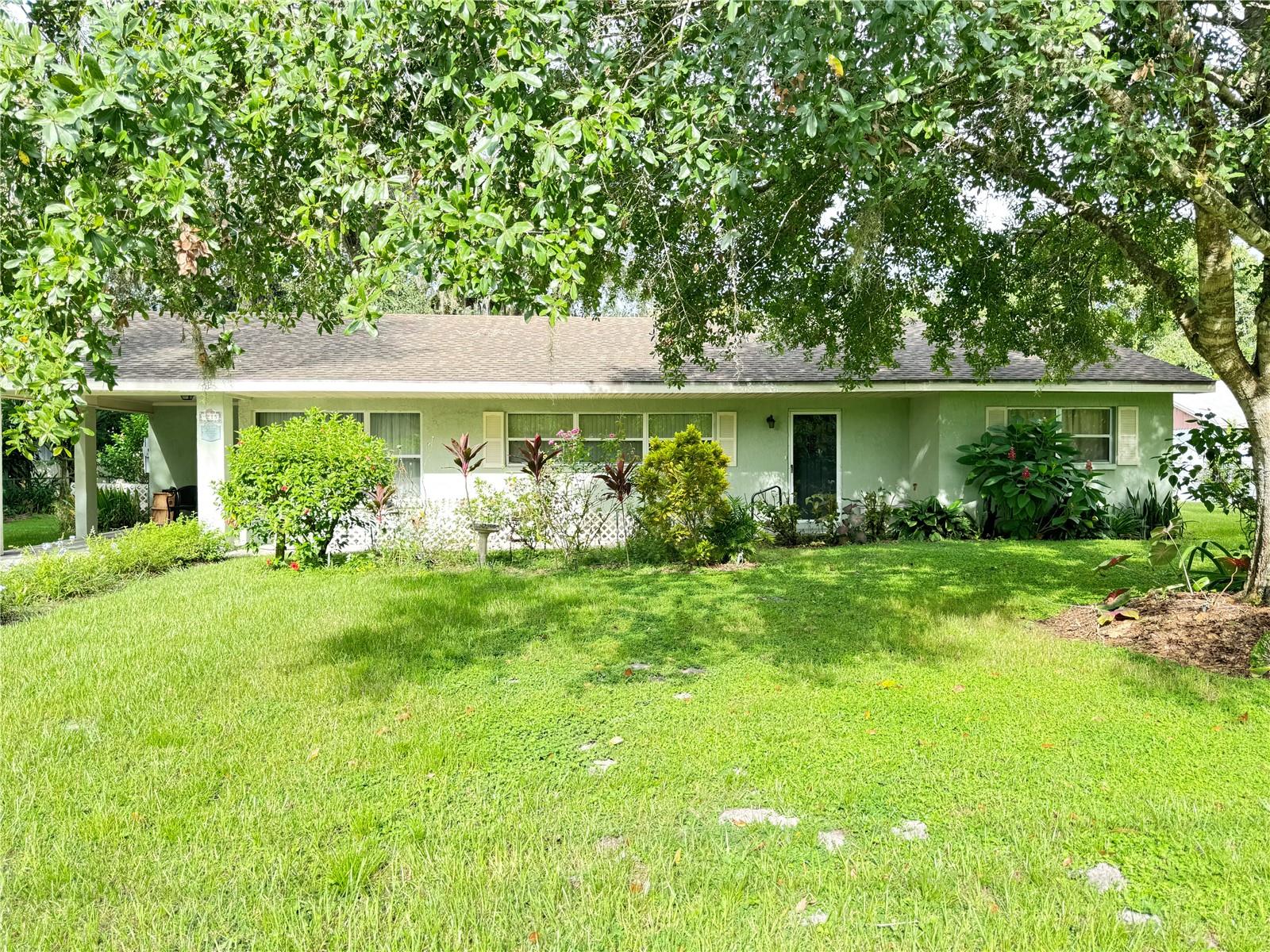 Charming 2-bedroom, 1-bath home featuring a spacious living room and a separate dining area perfect for gatherings. A versatile bonus room offers the ideal opportunity to create a 3rd bedroom, family room, or home office to suit your needs. The home also includes a convenient carport and a large laundry room with direct access to the backyard—making everyday living easy and functional. The lovely home is nestled under a shady mature oak tree with beautiful Florida flowers planted all around the yard. Very close to Hwy 60, downtown Bartow, schools and shopping.