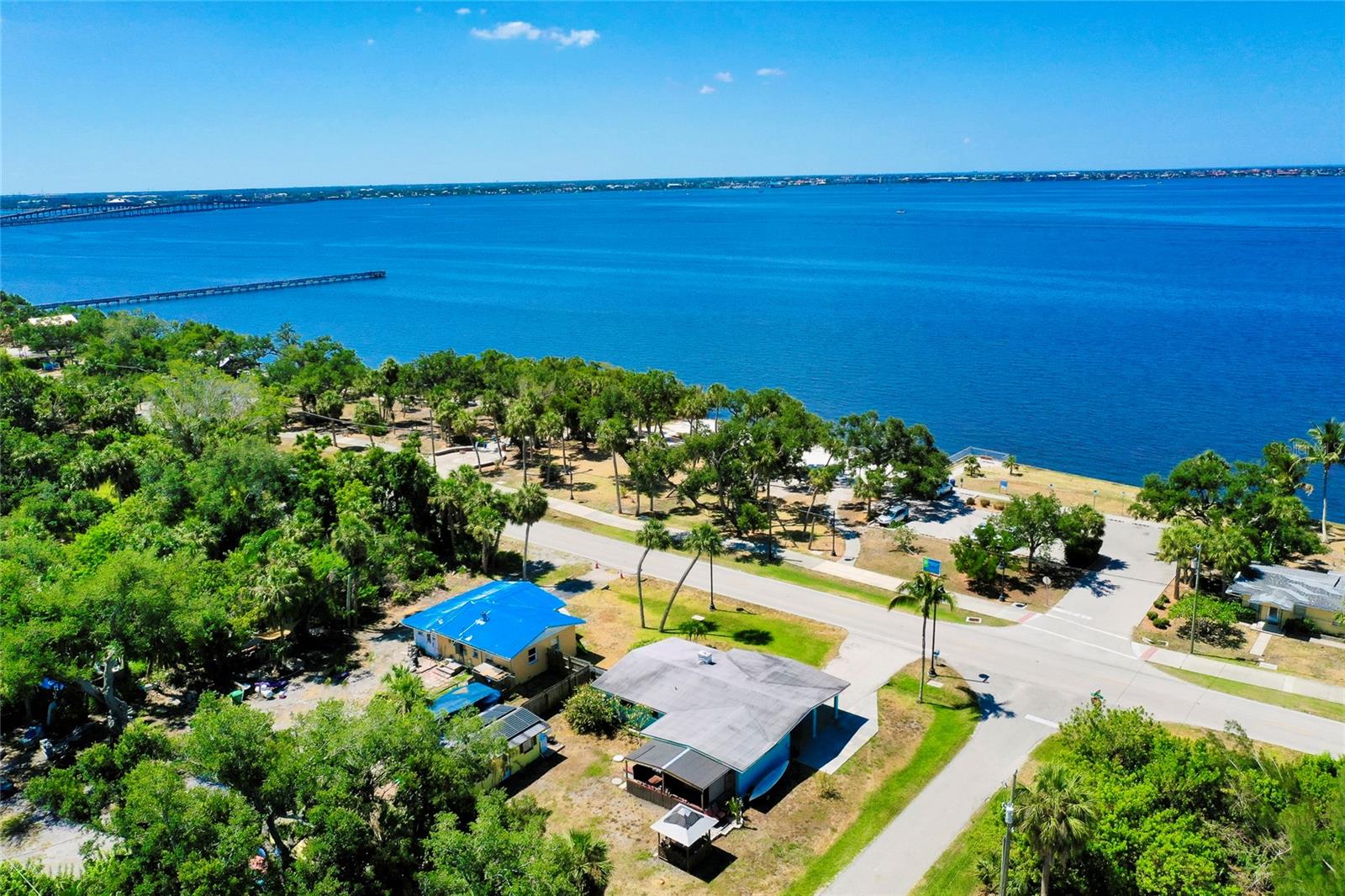 This 1958 bungalow in the heart of Port Charlotte, Florida, presents a unique opportunity for buyers seeking a renovation project. Located directly across the street from Bayshore Live Oak Park, the property offers immediate access to coastline trails, playgrounds, picnic pavilions, fishing piers, and boat access—plus a less than 2-minute drive to the Sunseeker Resort Charlotte Harbor.
The home has sustained flood damage and is being sold as a fixer-upper. The main house spans 1,392 sq ft, with 2 bedrooms and 1 bathroom, set on a generous 0.35-acre corner lot shaded by mature oak trees. The property also includes a covered back porch, gazebo, storage shed, and a cozy in-law apartment ideal for future rental potential once restored.
This is a fantastic opportunity for investors, flippers, or anyone eager to bring this bungalow back to life and enjoy its prime location with unobstructed views of Charlotte Harbor.