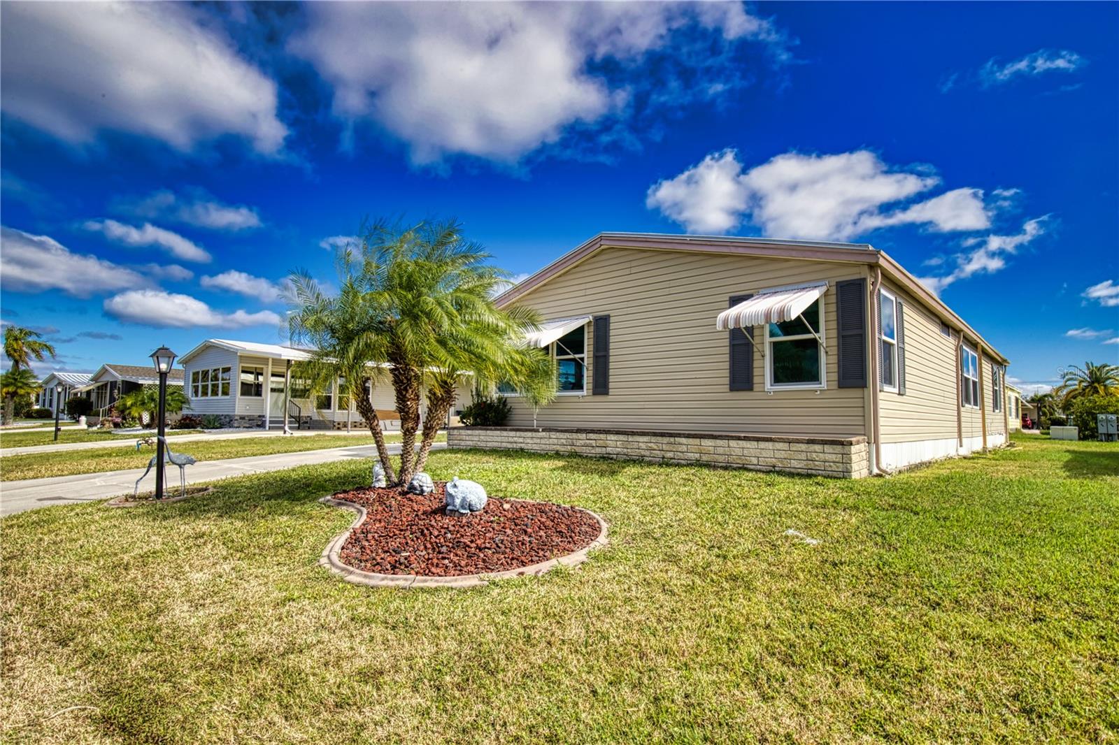 The ultimate lifestyle on Florida's Gulf Coast, located between Sarasota and Fort Myers with boat access to the Gulf. La Casa is a quiet 55+ community of 974 homes nestled among a variety of native trees. Spacious common grounds surround our eight lakes. Welcome To the Good Life! RECREATION, 2 Clubhouses, 2 Heated Pools. There is no shortage of activities in this community! 2 Bedroom, 2 Bath. Open floor plan w/spacious kitchen, living and dining room areas. Kitchen w/built-in cabinets at entry, appliances. Dining room w/built-in hutch. Front entry to family room w/wet bar, front awning and lake views. Hall linen closet. Guest bedroom w/laminate floor, brightened by corner windows features a large walk-in closet. Guest bath w/wainscotting, new vanity, walk-in tiles shower. Primary bedroom w/laminate floor, walk-in closet. Primary bath w/wainscotting, new vanity, new walk-in tiles shower and safety bars. Luxury waterproof vinyl. New windows 2017. A/C 2018, humidistat, ceiling fans. Ducts replaced 2019. Home sided in 2018. The home features vaulted ceilings throughout and a split floor plan offering privacy for you and your guests. Driveway to a tiled patio area. Utility room w/tiled floor, washer, dryer. New Carport installed!