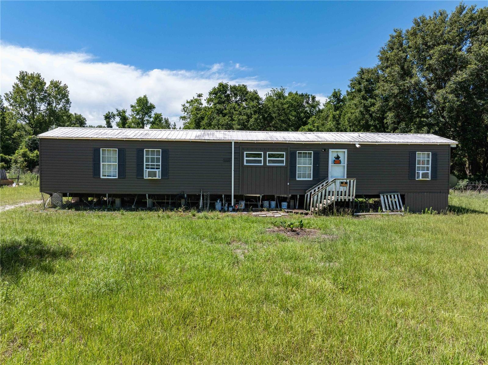 USDA Zero down Financing Eligible! This four-bedroom, two-bathroom spacious open plan single-wide manufactured home sits on a large 8-acre lot with no HOA or CDD, offering plenty of room and privacy. Located on a quiet, no through traffic area. The home provides a peaceful setting while still being conveniently close to shopping, schools, restaurants, and medical facilities. The property is in good overall condition and ready for your personal touch to make it truly yours. Metal roof and laminate flooring throughout. The interior features an inside laundry area, and the exterior boasts a deck and shed for extra storage. Newly painted both interior and exterior. Perfect for farming, raising animals, or simply enjoying the wide-open space. Whether you're investing in agricultural land, or just enjoying a quiet rural lifestyle with convenient access to town, this property is for you! Sold AS-IS.