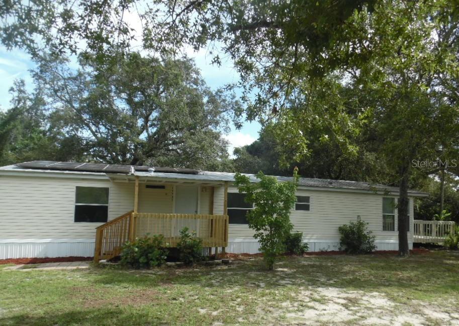 This is a beautiful Double Wide manufactured 1996 home situated on a fenced 1.16 acre property. In 2007 a 720 sq ft detached concrete block garage /workshop was added. In 2025, the home was remodeled with new flooring - laminate everywhere except bedrooms which have carpet - , interior painting throughout, new kitchen cabinets and appliances, and new bathroom vanities and fixtures. The hot water heater was also replaced and a new front deck was added. This property is semi-rural, with lots of elbow room. It is on well and septic and the large workshop/garage could be just the added feature you have been looking for. There are 3 bedrooms, 2 bathrooms, a utility room and a delightful eating area in the country kitchen with large windows and a slider opening to the second wood deck