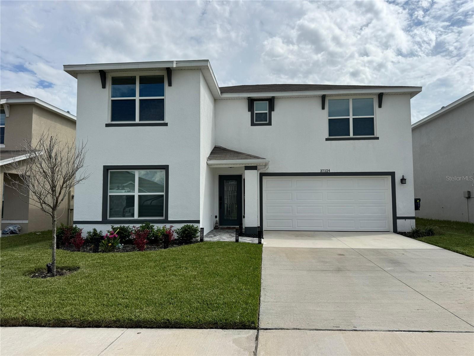 Welcome to this exceptional Zephyr Ridge residence, built in 2023 and extensively upgraded in 2024–2025 with modern luxury features inside and out. The open concept design showcases fresh satin white paint, new LVP flooring, motorized blinds, and a full Pyle surround sound system. The gourmet kitchen is a centerpiece with quartz countertops and backsplash, a waterfall island, custom gold hardware, square sink with air disposal, 5-stage osmosis filtration system, and upgraded appliances including a range with air fryer oven and flush microwave. Elegant finishes continue with wainscoting, custom closets, upgraded bath vanities, and 6” baseboards. Systems include a tankless water heater, water softener, and Wi-Fi A/C drain. Outdoors you’ll love the 25’x27’ concrete patio, stone tile entry, fiberglass security door, chandelier lighting, and ceiling storage racks. Ideally located near Publix, dining, golf, Wiregrass Mall, Tampa Premium Outlets, and just 45 minutes from Tampa. Move-in ready elegance in a vibrant community with pool amenities.