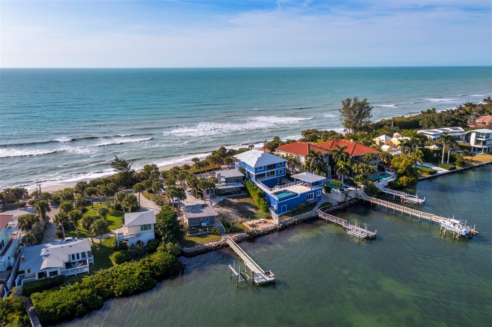 Double Your Pleasure: Two Beaches, One Visionary Opportunity on Casey Key. Why settle for one beach when you can own both? This exceptional Gulf-to-Bay property on exclusive Casey Key offers the rare opportunity to enjoy 89 feet of private beachfront on the Gulf of Mexico and a newly expanded sandy shoreline along Blackburn Bay—an extraordinary transformation brought on by recent storms that created a unique dual-beach experience. Spanning .58 acres, this property is a true canvas for visionary living. Imagine designing a custom architectural masterpiece where every window frames breathtaking sunrises over the bay and glowing sunsets over the Gulf. From boating to beachcombing, the possibilities are endless with your own private dock, Gulf-front beach, and tranquil bay access—ideal for paddleboarding, kayaking, and launching your next waterfront adventure. The existing vintage 1951 beach cottage exudes a nostalgic charm, reminiscent of a bygone era. With pecky cypress siding, a cozy brick fireplace, and an elevated split-level design, it feels like your grandparents’ beach house—warm, quirky, and full of character. Inside, you'll find two bedrooms, two full baths, and a surprise third bathroom cleverly tucked into the laundry room with a shower, toilet, and utility sink for added functionality. A rooftop deck crowns the home, offering panoramic Gulf-to-Bay vistas that must be seen to be believed. Recent upgrades include two new AC units (2024) and a roof replacement (2015). The elevated structure stayed dry during recent storms, and new garage doors offer peace of mind. Whether you're planning to live here while finalizing design plans or simply looking to landbank a premium Gulf-to-Bay lot, the rental income potential is significant. Zoned for single-family use, Casey Key invites you to create something truly extraordinary. This location, near the coveted south bridge, provides easy access to fine dining, boutique shopping, entertainment, and Venice Airport for private travel. Surrounded by multi-million-dollar estates, this is a once-in-a-lifetime opportunity to claim one of the most dynamic waterfront parcels on Florida’s west coast. Schedule your private tour today and envision the future—where your dream home bridges the Gulf and the bay in timeless style.