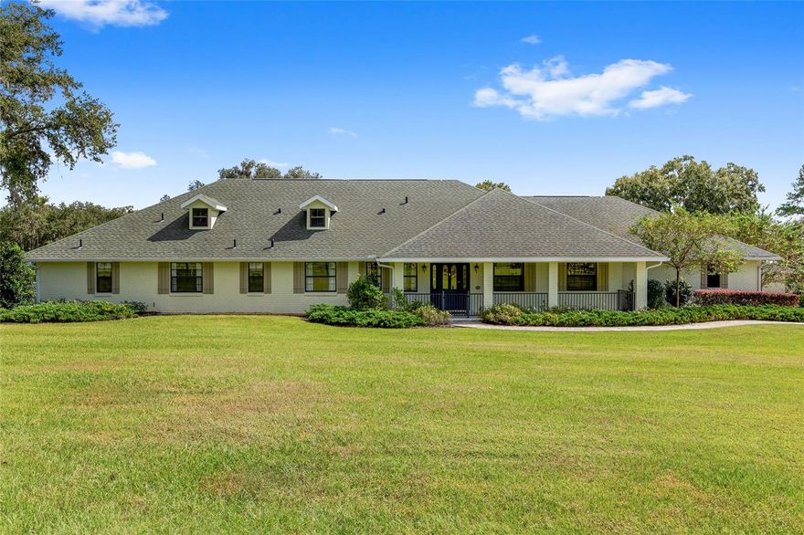 Tucked into the heart of NW Ocala’s horse country, this beautifully kept farm sits on just under 14 acres in the quiet Field of Dreams neighborhood. Just minutes from WEC, HITS, and everyday amenities, it’s the kind of property that feels private yet close to everything.  
A tree-lined drive leads you through rolling, manicured pastures toward the barn, arena, and home. The residence is surrounded by mature landscaping, with a welcoming front patio and a classic paver walkway that sets the tone right from the start. Inside, the home is light, bright, and recently updated,  offering 3 bedrooms, 2.5 baths, plus a den/office. Upgrades include cherry and cork wood floors, fresh finishes throughout, and plenty of natural light.
The great room was designed for comfort and entertaining, with cathedral ceilings, large windows, and a floor-to-ceiling wood-burning fireplace. The kitchen has been completely redone with custom cabinetry, premium appliances (GE Profile range with air fryer, Fisher & Paykel fridge and dishwasher, and Viking microwave), a center island with breakfast bar, and a charming breakfast nook with bay window views overlooking the pool.
The split-bedroom layout gives guests privacy, with two spacious guest rooms sharing a Jack-and-Jill bath with dual vanities. The main suite stands out with its own screened lanai, two walk-in closets, and a brand-new en-suite featuring granite counters and a walk-in shower. French doors from the kitchen open to a screened patio and the resort-style pool area beyond surrounded by lush gardens, paver walkways, and built-in seating for relaxing or entertaining.
A detached guest area sits just off the pool, offering two private bedrooms, each with its own bath, and a small exterior kitchenette — perfect for visiting friends or family.
For the horses, the farm is well thought out and functional. There are five 3-board fenced paddocks, each with water, plus a concrete block center-aisle barn with five matted stalls, 20' ceilings for airflow, fly-spray system, wash rack, and tack room. The new 70’ x 180’ irrigated arena with Fleet Footing is ready for year-round training.
A 1,000-gallon buried propane tank and whole-house generator were recently installed, adding peace of mind during storm season.
If you’ve been looking for a move-in ready horse property in one of Ocala’s most desirable areas, close to everything yet peaceful and private, this one checks every box.