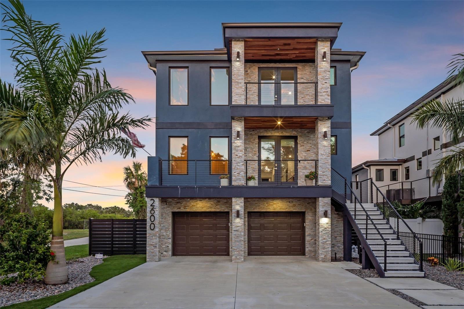 This magnificent 2-year-old home overlooks a 170-acre nature preserve and may be the best house in Gulfport! The current owners built it with every available upgrade to be their forever home but have decided to move closer to their grandbabies — so come see this amazing property.--
Built in 2023, this three-story block home offers 4 bedrooms, 4 bathrooms, 2754 sq ft of living space, over 700 sq ft of balconies, an oversized 4-car attached garage, and a custom elevator.
Perhaps the home’s best feature is the two-story screened-in saltwater pool, complete with a Jacuzzi, two waterfalls, and a fire feature. Just off the pool is ample shaded lounging space and an outdoor kitchen. The screened enclosure provides SPF 35 protection, making this entire area a true extension of the home — perfect for seamless indoor-outdoor living.
The main living area features an open-concept great room with a massive 4-panel sliding glass wall that completely opens to a 17' x 14' outdoor living deck, providing stunning views of Clam Bayou Preserve. The kitchen is equipped with a granite-slab waterfall island, two-tone custom cabinetry, a wall-mounted hood, a built-in wine refrigerator, and numerous high-end upgrades.
The owner’s suite includes a private balcony, dual vanities, a large walk-in closet, and a spa-style ensuite bathroom. All bathrooms feature heated, backlit mirrors. Additional highlights include energy-saving Low-E double-pane impact windows, R-38 insulation, and a 40-year metal roof. This home offers so many more upgrades that it’s impossible to list them all — call or text today to schedule a showing!