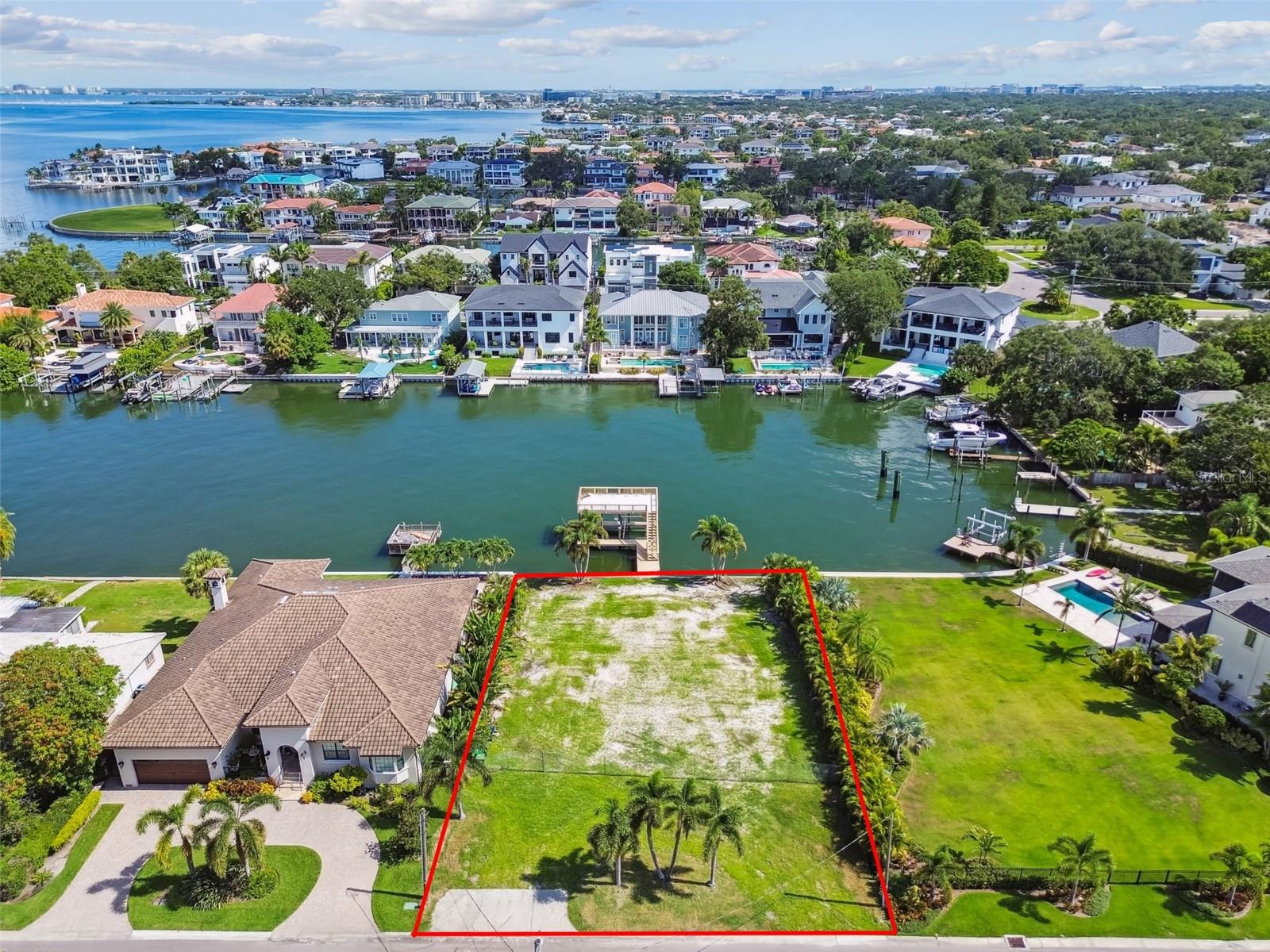 Welcome to one of South Tampa’s most coveted waterfront opportunities in the prestigious Sunset Park Isles neighborhood. This cleared, ready-to-build lot spans 95 x 130 feet and sits 7 feet above sea level, offering a rare combination of elevation, location, and deep-water access. Nestled along the widest canal in the area—an impressive 240 feet across with estimated depths over 15 feet—this property is a boater’s dream with direct access to Old Tampa Bay in just 3 minutes! Enjoy breathtaking water views and the ultimate coastal lifestyle with a grandfathered-in two-story boat house featuring a 5,000 lb covered boat lift, electric and water hookups, and an upper-level viewing deck perfect for sunset cocktails or morning coffee. The concrete seawall and sailboat water designation ensure smooth navigation and long-term stability. Located in Flood Zone AE, the lot is primed for a luxury custom build with utilities already available, including public water and sewer, natural gas, electricity, cable, and high-speed internet. With no HOA and top-rated schools—Dale Mabry Elementary, Coleman Middle, and Plant High—this fee simple property offers the freedom to design your dream home in one of Tampa’s most desirable waterfront communities. Whether you're an avid boater, luxury home builder, or investor seeking a rare gem, this lot delivers unmatched value and potential. Don’t miss your chance to own this once-in-a-lifetime waterfront property. Schedule your private showing today!